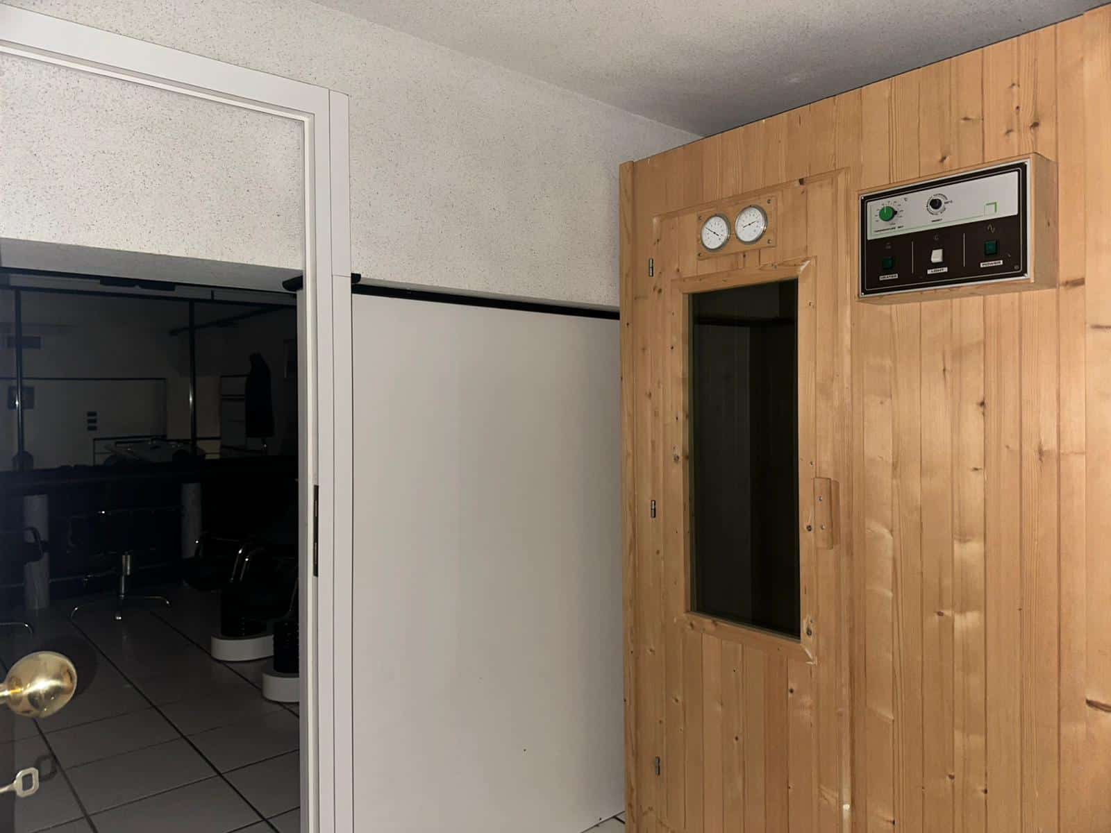 Sauna in legno con pannello di controllo e termometri, ambienti moderni e accoglienti, ideale per relax e benessere, ideale per wellness center e case private, foto di alta qualità.