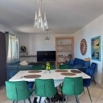 Luminosa zona living con tavolo da pranzo, divani blu e pareti decorative, arredi moderni, ambienti spaziosi, stile elegante e accogliente, ottima soluzione per casa dotata di charme e funzionalità.
