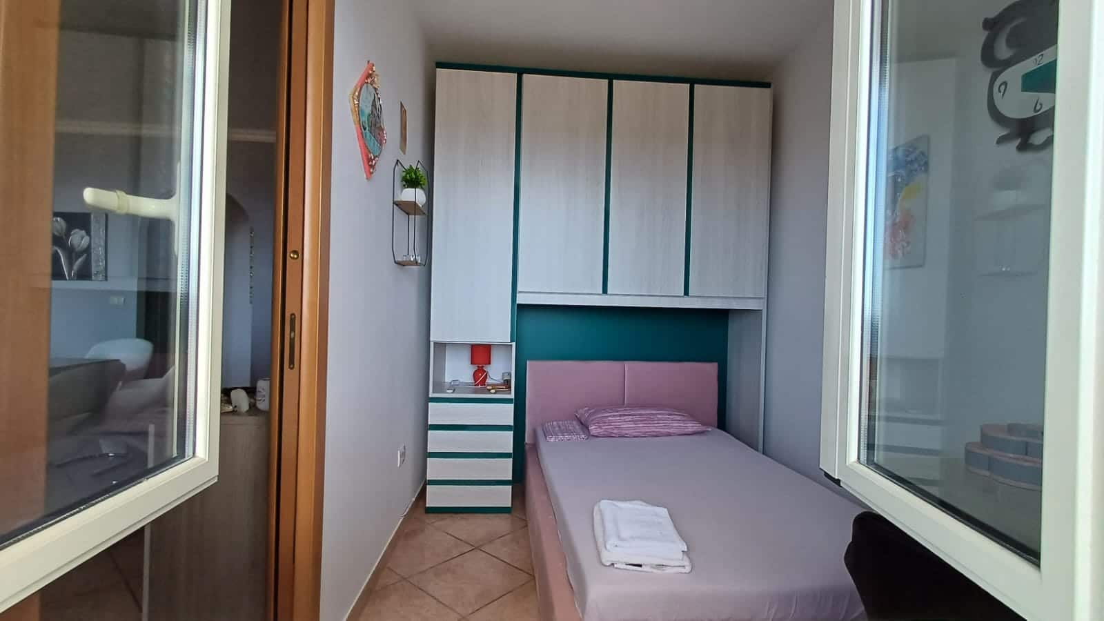 Arredo camera da letto con armadio a muro, letto singolo e dettagli moderni, ideale per immobiliare e affitti turistici.