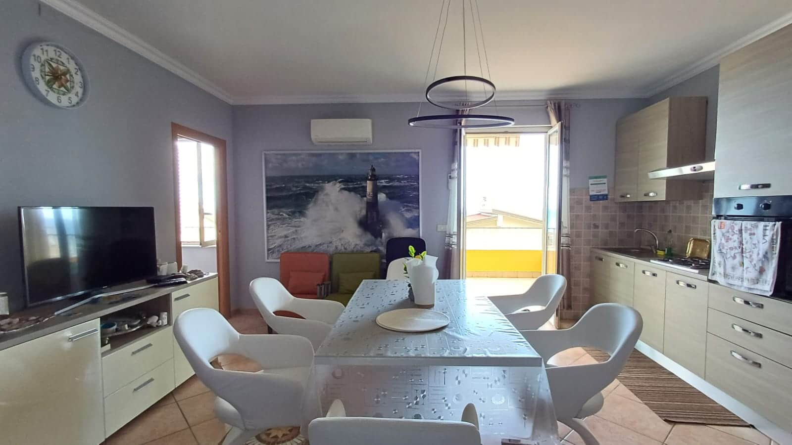 Luminoso soggiorno con cucina a vista e balcone, arredato con stile moderno, in un appartamento in affitto a NextCasa. Ambiente accogliente con dettagli funzionali e decorativi per il massimo comfort.