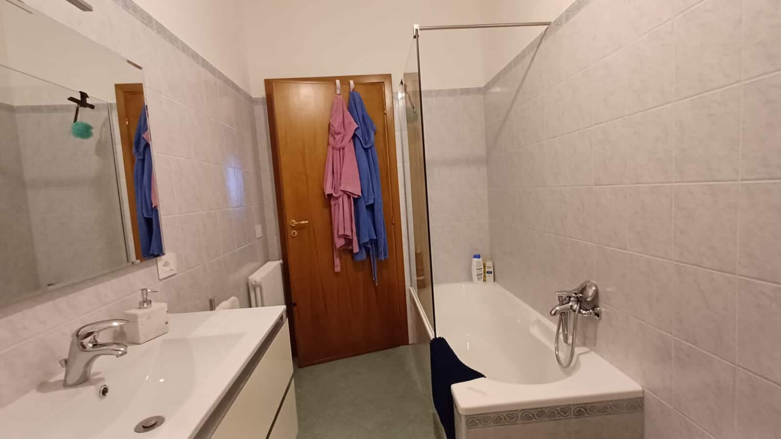 Bagno con lavandino e vasca da bagno, stanza da bagno moderna e funzionale, arredamento pratico per uso quotidiano, dettagli di ristrutturazione e pulizia, ideale per appartamenti e case private.