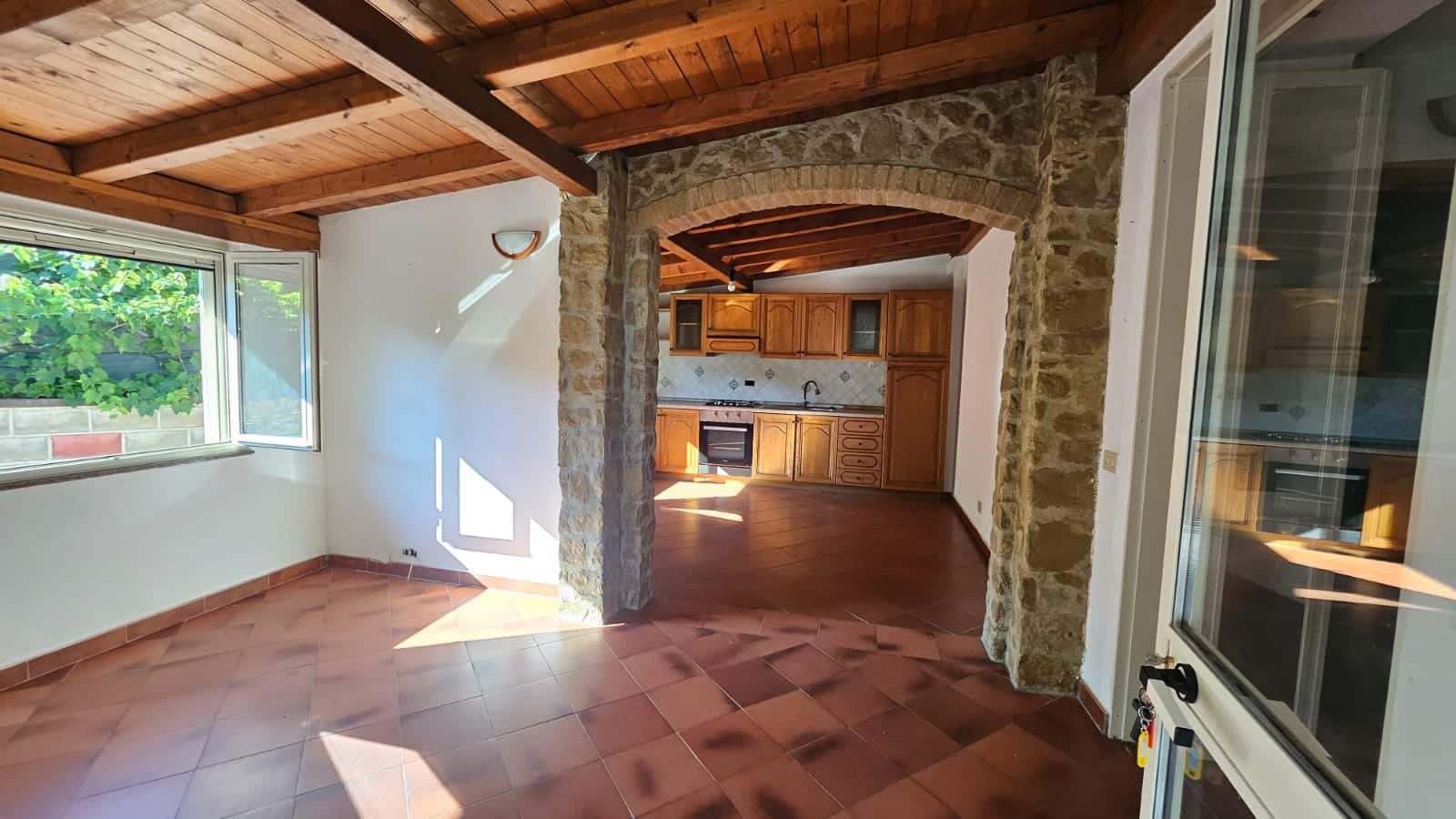 Rustico in vendita con soggiorno luminoso e cucina in stile classico, caratterizzato da pareti in pietra e soffitto in legno, ideale per vivere in comfort e stile.
