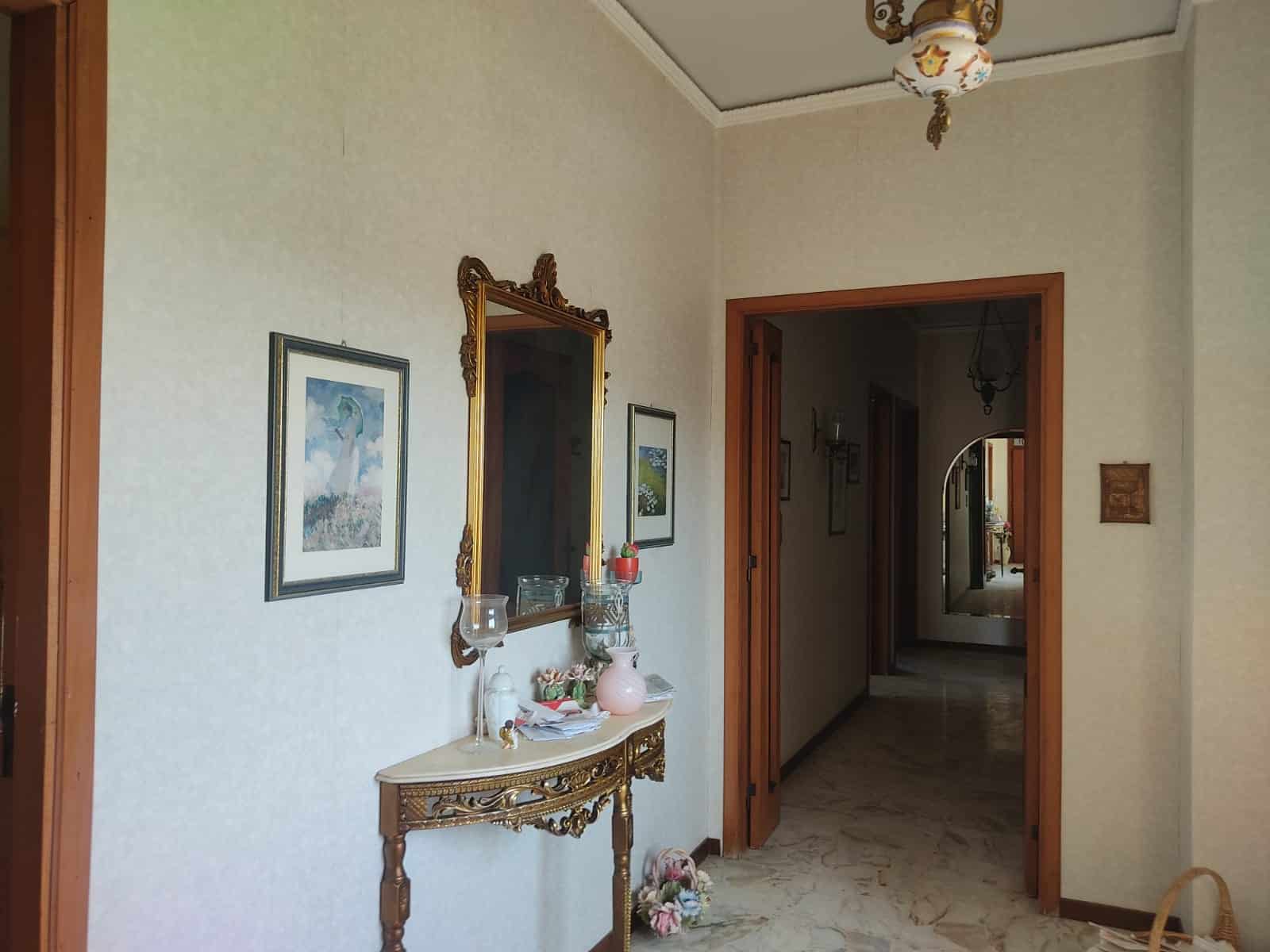 Portafinestra in legno, ingresso elegante con specchio dorato, decorazioni vintage, arredamento classico, casa di prestigio, interior design italiano, NextCasa, stile tradizionale italiano, dettagli raffinati, ambiente accogliente, fotogallery immobili di lusso.