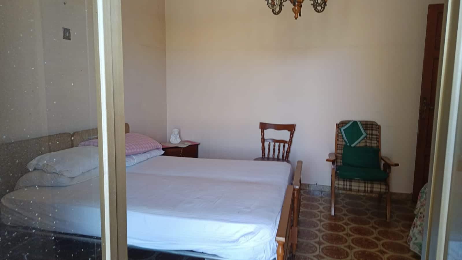 Letto matrimoniale in camera da letto con arredi classici, letto in legno, camera accogliente e luminosa, ambiente tranquillo per riposo e relax.
