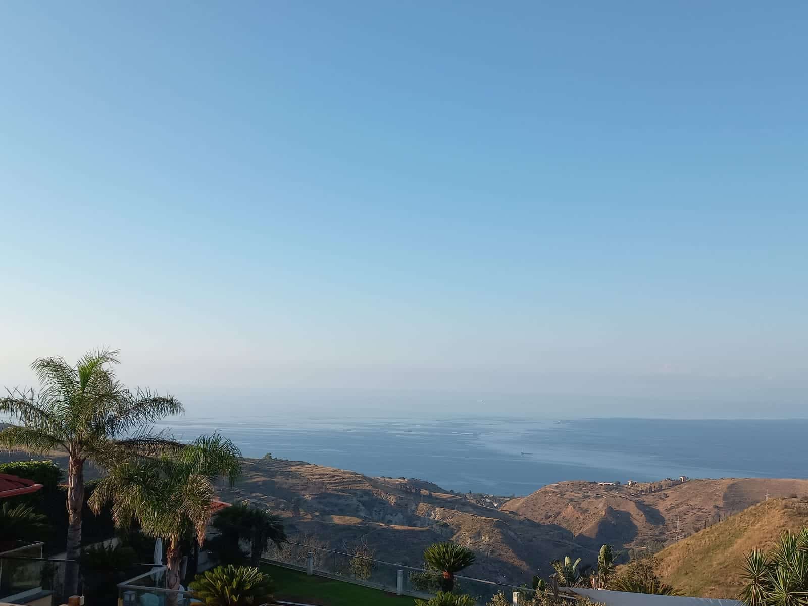 Vista panoramica sulla costa e sul mare con paesaggi montuosi e vegetazione tropicale, perfetta per risaltare la posizione esclusiva di immobili di lusso NextCasa in zone scenic.
