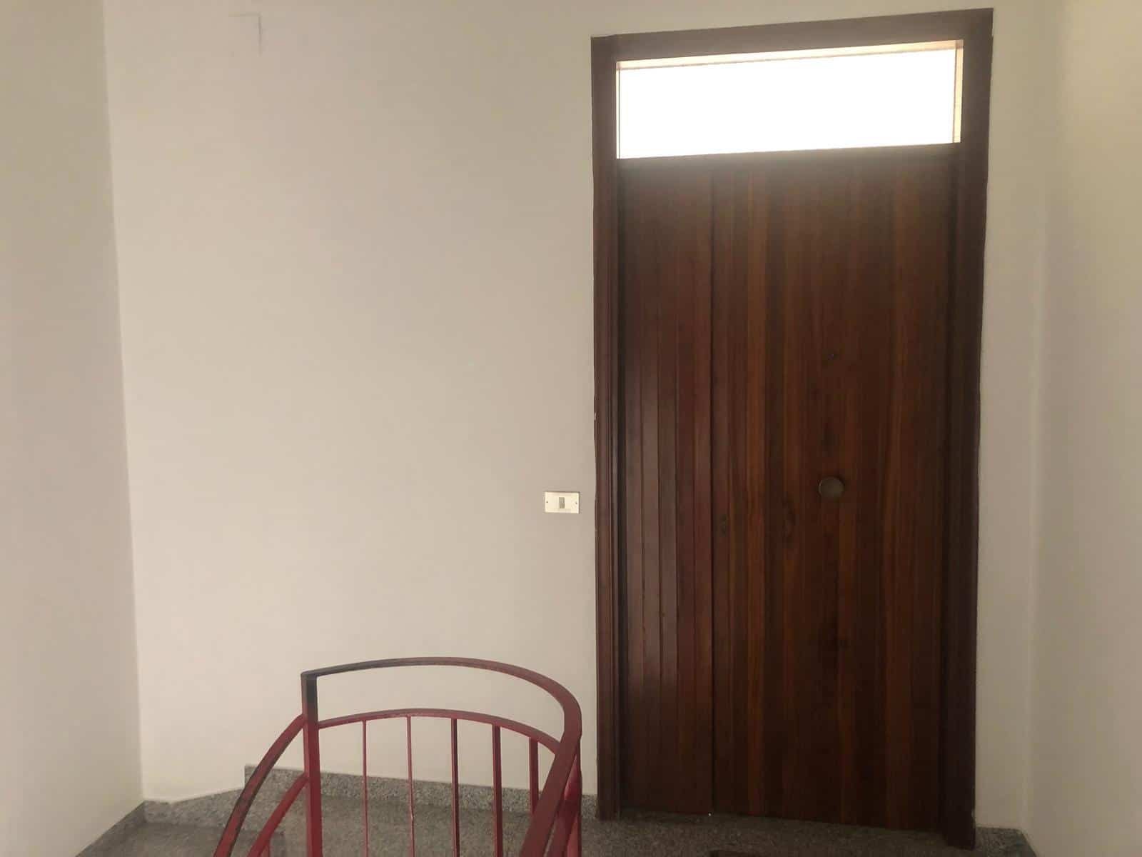 Porta di legno massiccio con finestra superiore, ingresso elegante e moderno a casa o appartamento, design minimalista e accogliente, ideale per ambienti residenziali raffinati.