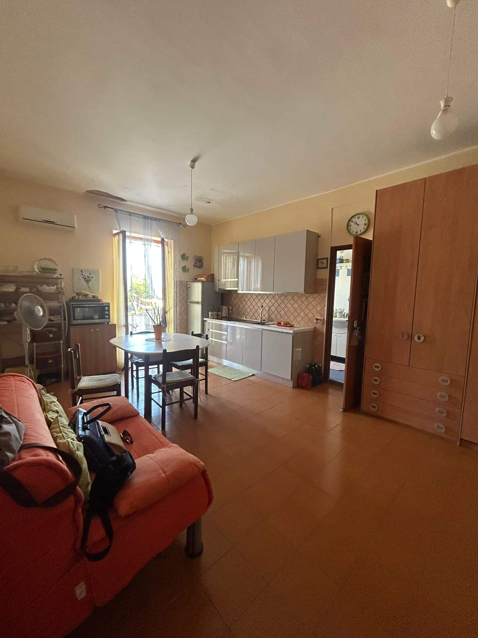Ampia zona giorno con cucina a vista, divano e zona pranzo in casa NextCasa, ambiente luminosa, con parquet, arredi pratici e caldi, ideale per vivere in comfort e stile.
