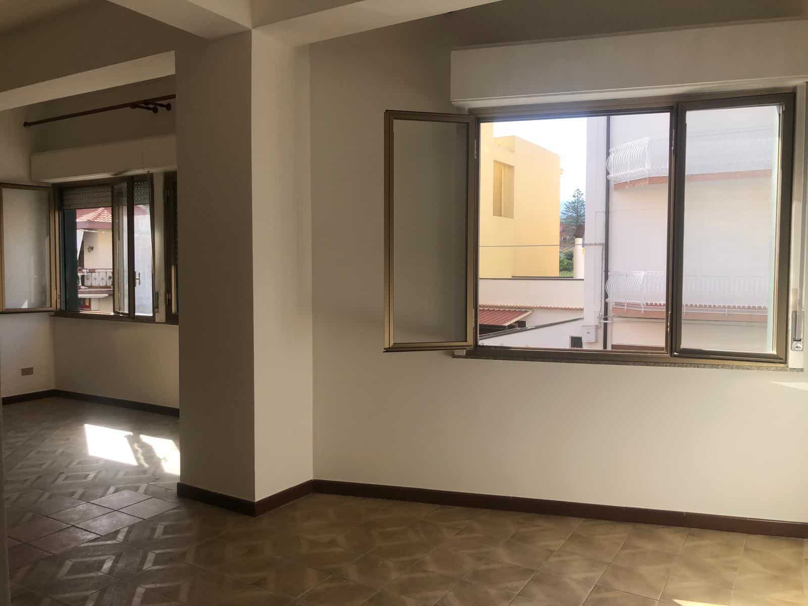 Finestra grande in appartamento residenziale con vista su edifici circostanti e luce naturale, ambiente luminoso e spazioso ideale per la vendita immobiliare NextCasa.