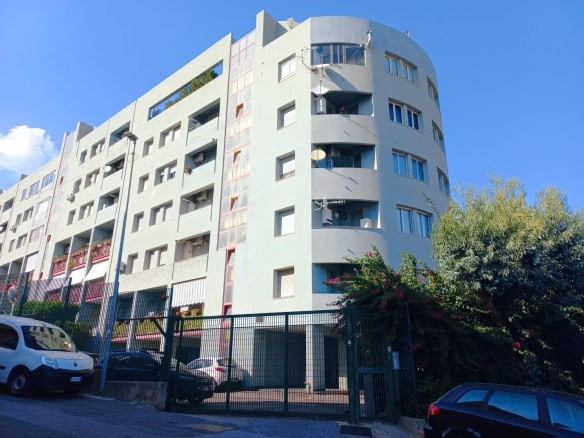 Fase urbana di un edificio residenziale moderno con balconi e finestre panoramiche, ambienti ideali per soluzioni di housing e investimento immobiliare.
