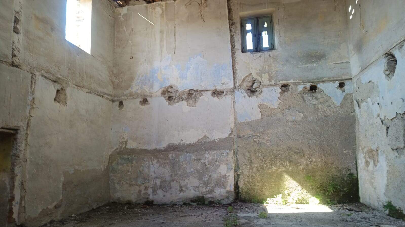 Vecchia casa in rovina con muri in pietra e piccole finestre, pronta per ristrutturazione, nel contesto di immobili da restaurare e riqualificare, tipico di proprietà storiche e immobili di valore.