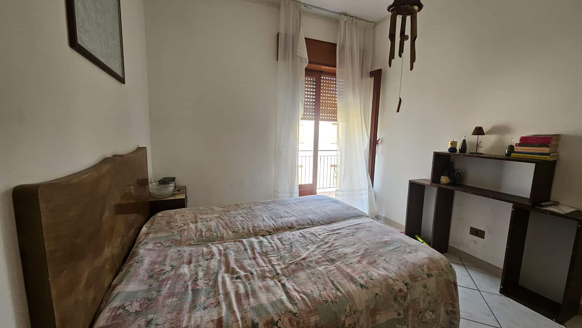 Letto matrimoniale in camera da letto con arredi semplici e luce naturale, ideale per case in affitto o vendita, perfetto per evidenziare comfort e funzionalità degli immobili residenziali.
