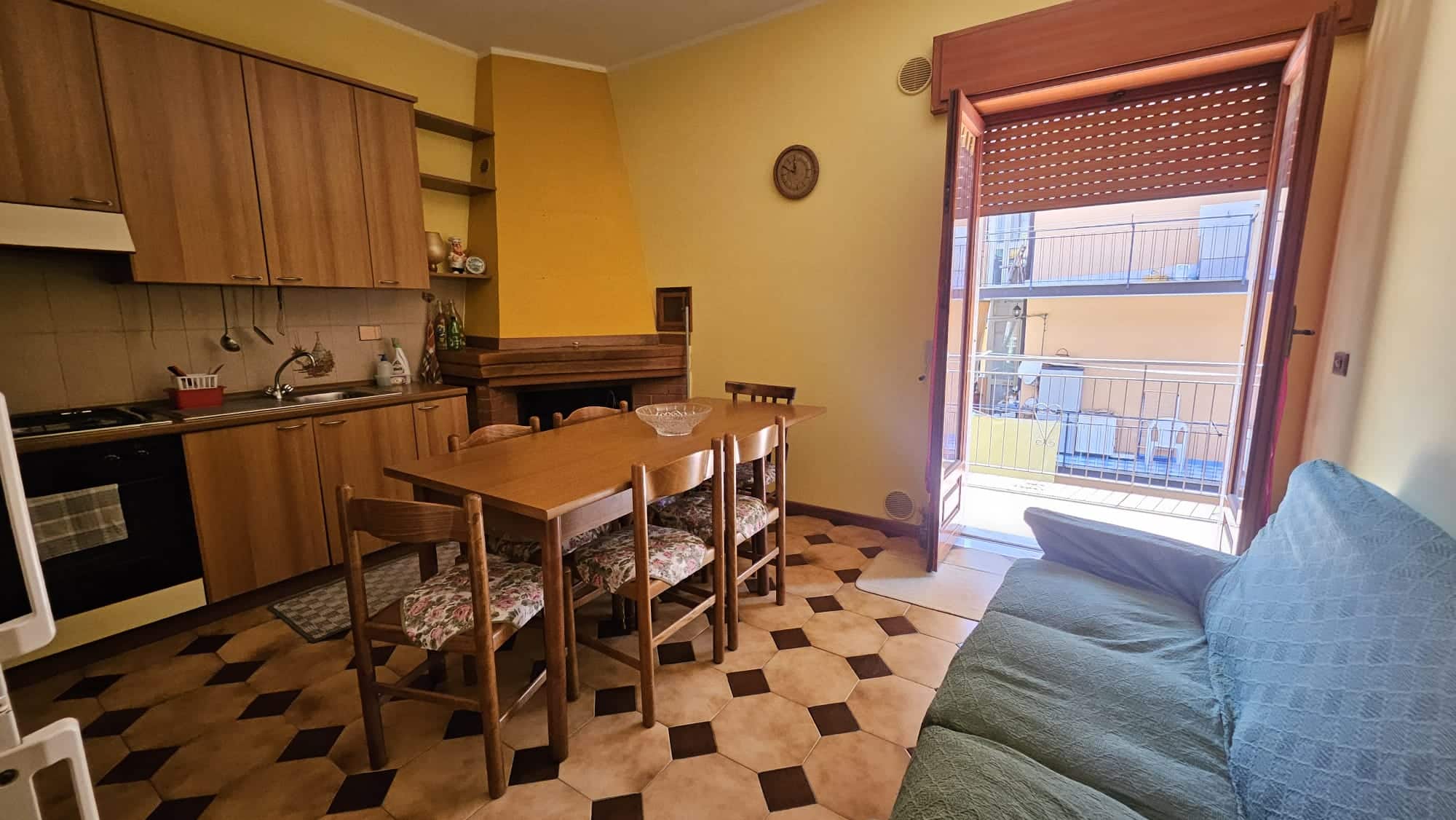 Appartamento con soggiorno e cucina in stile classico, balcone con vista urbana, arredamento caldo e accogliente, ideale per soggiorni di breve o lungo termine a Napoli.