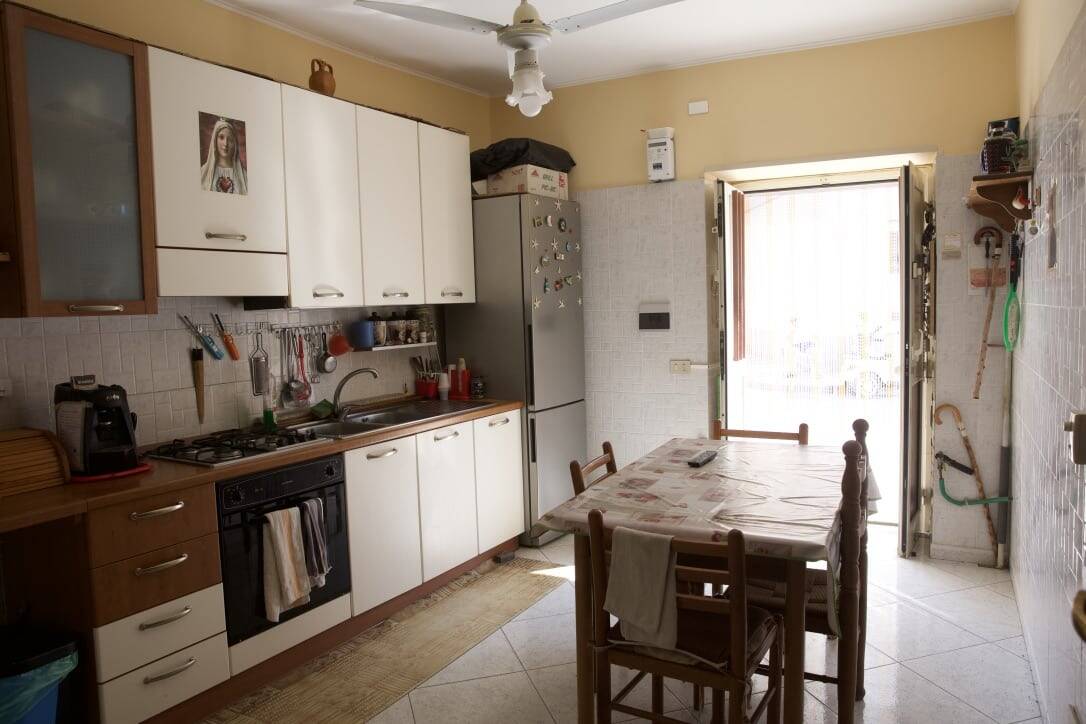 Pentole cucina, frigorifero, tavolo da pranzo, arredamento abitazione, cucina abitabile, ambiente domestico, NextCasa Italia, soluzioni di arredo rustico e pratico.