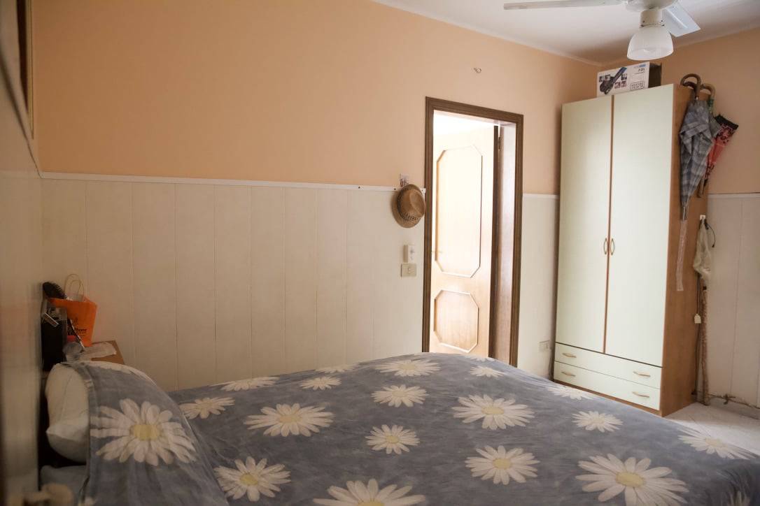 Camera da letto con letto matrimoniale, armadio e arredamento funzionale, ambiente accogliente e luminoso.