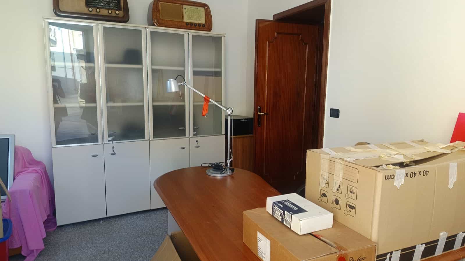 Armadio in vetro bianco per ufficio, stanza moderna con scatole di imballaggio e lampada da scrivania. Ideale per arredo ufficio, contenitori e mobili per spazio lavorativo.