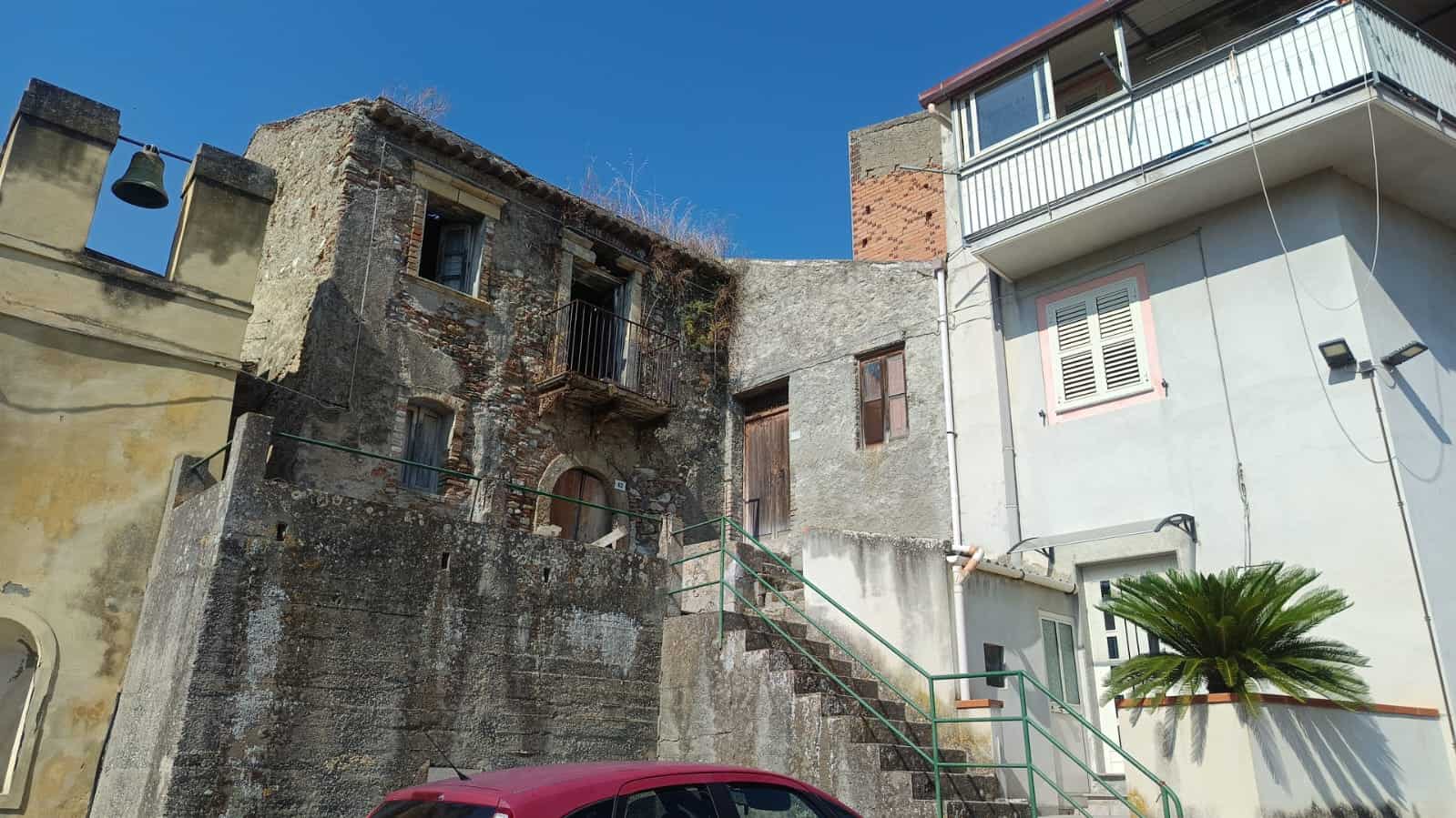 Vicolo con abitazioni storiche e ristrutturate in zona urbana, evidenziando l’architettura tradizionale e il contrasto tra costruzioni antiche e moderne, ideale per investimenti immobiliari.
