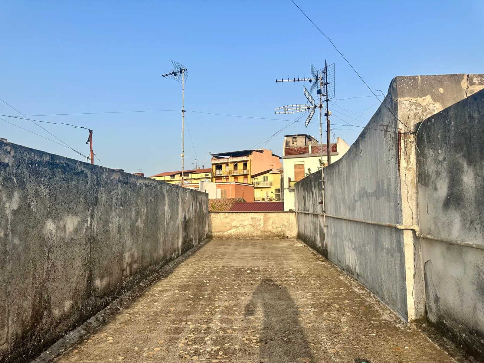Tetto privato con vista sulla città, adatto a progetti di ristrutturazione e investimento immobiliare, in un'area urbana con edifici residenziali e TV antenna.