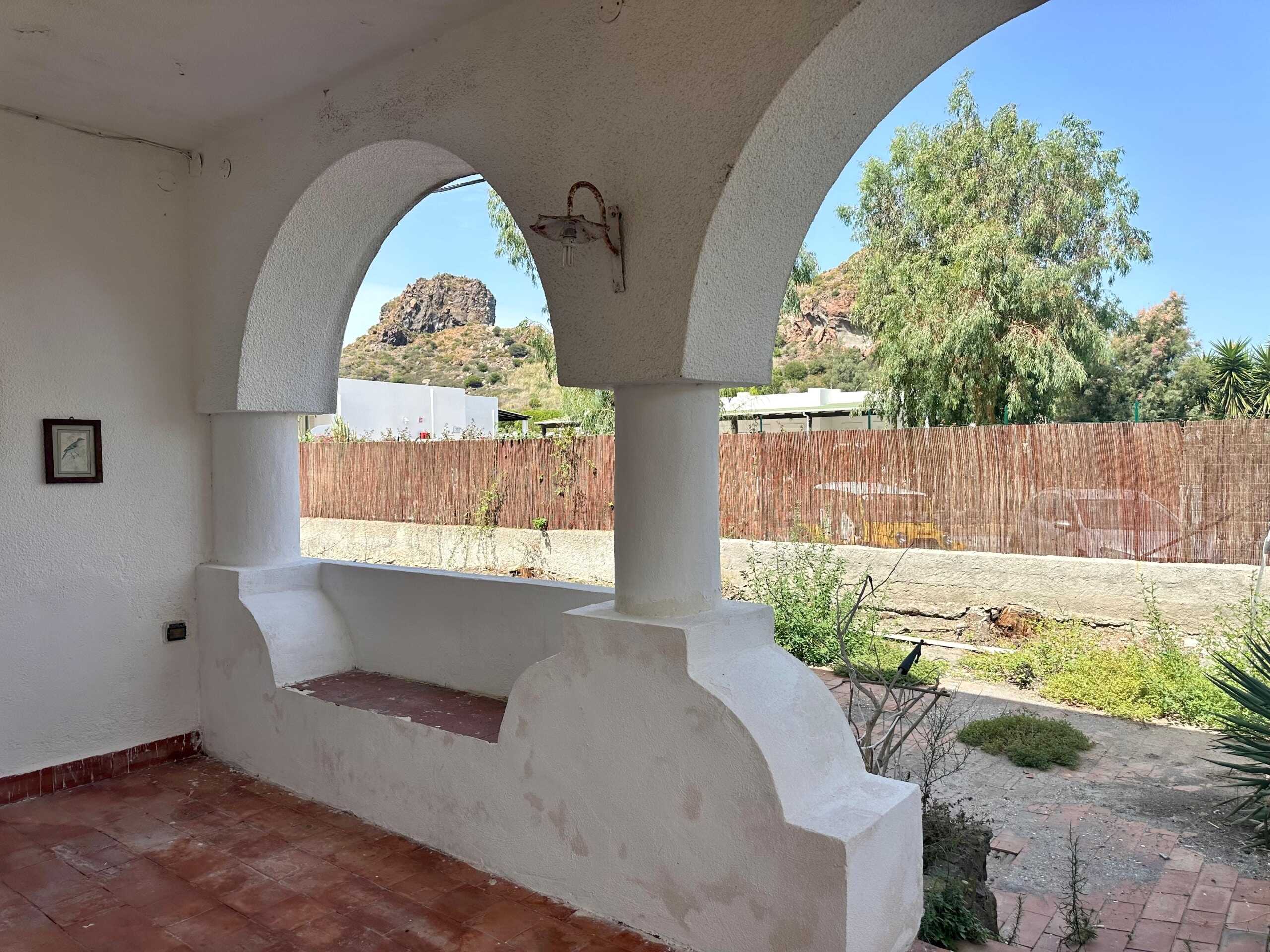 Benessere e tranquillità in una casa con veranda, ampia visuale sulle montagne e ambiente naturale, ideale per relax e momenti di convivialità all'aperto.