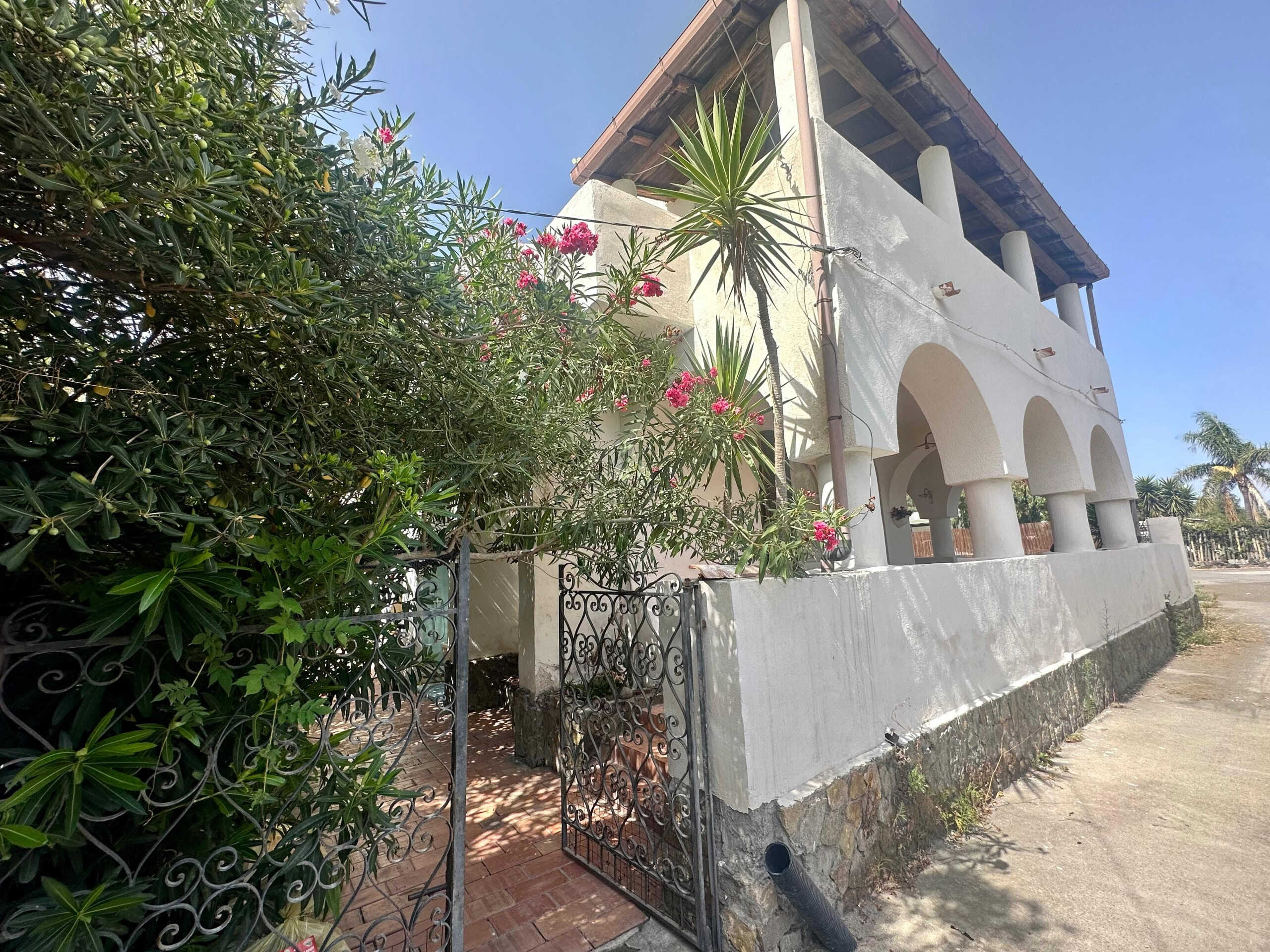 Villa bifamiliare con giardino e terrazza panoramica, stile mediterraneo, vicino al mare; soluzione ideale per vacanze e investimento immobiliare.