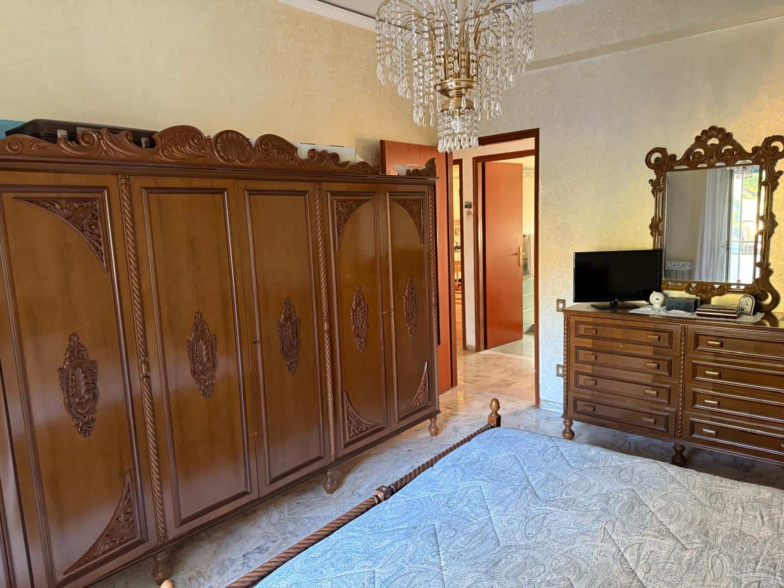 Armadio in legno con dettagli intagliati, mobile in stile classico in una stanza da letto.