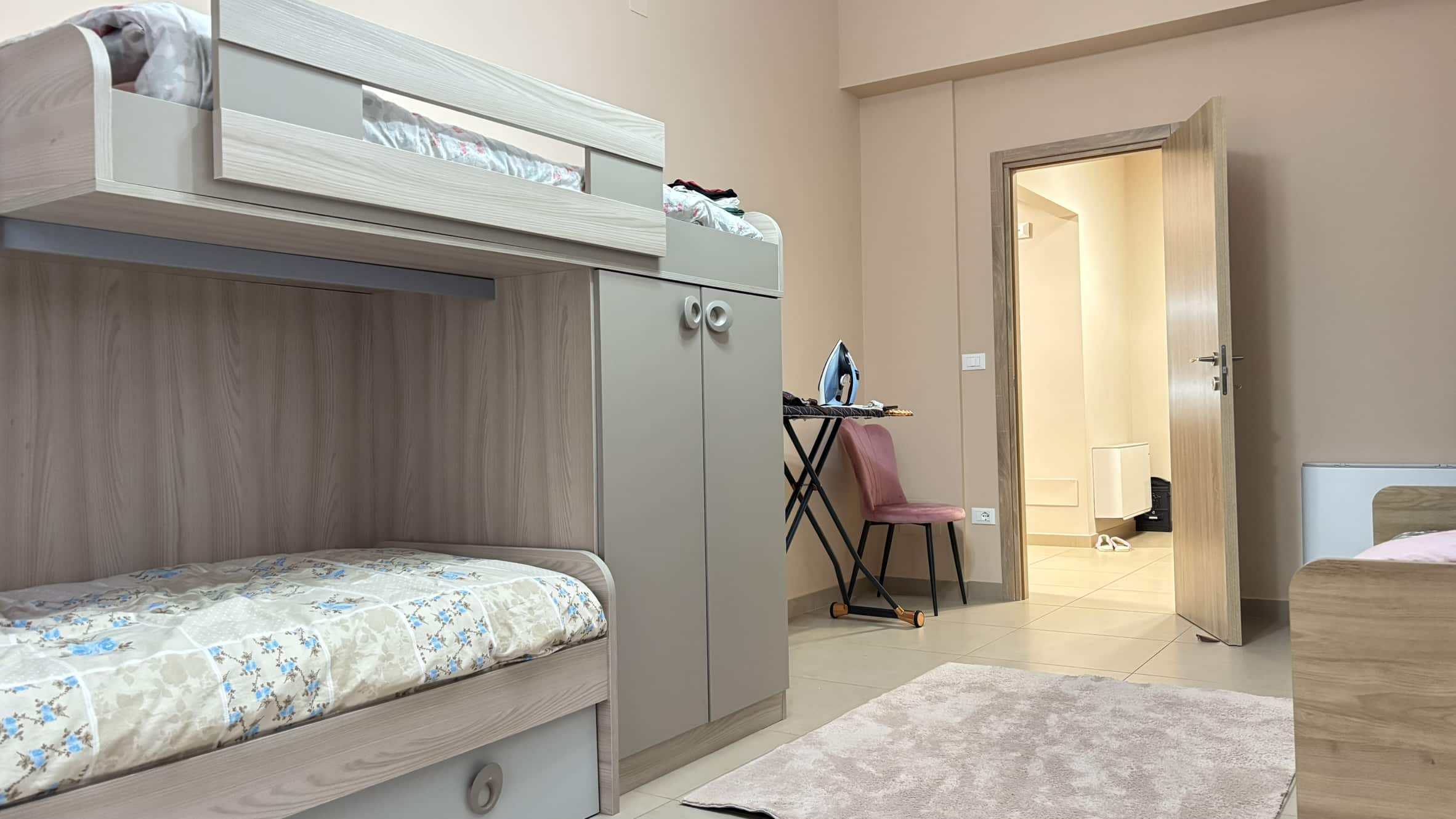 Letto a castello in camera, arredo moderno in stile minimalista, vista sull'ingresso, spaziosa stanza per affitti brevi, casa vacanza a Milano, NextCasa, alloggi comodi e funzionali.
