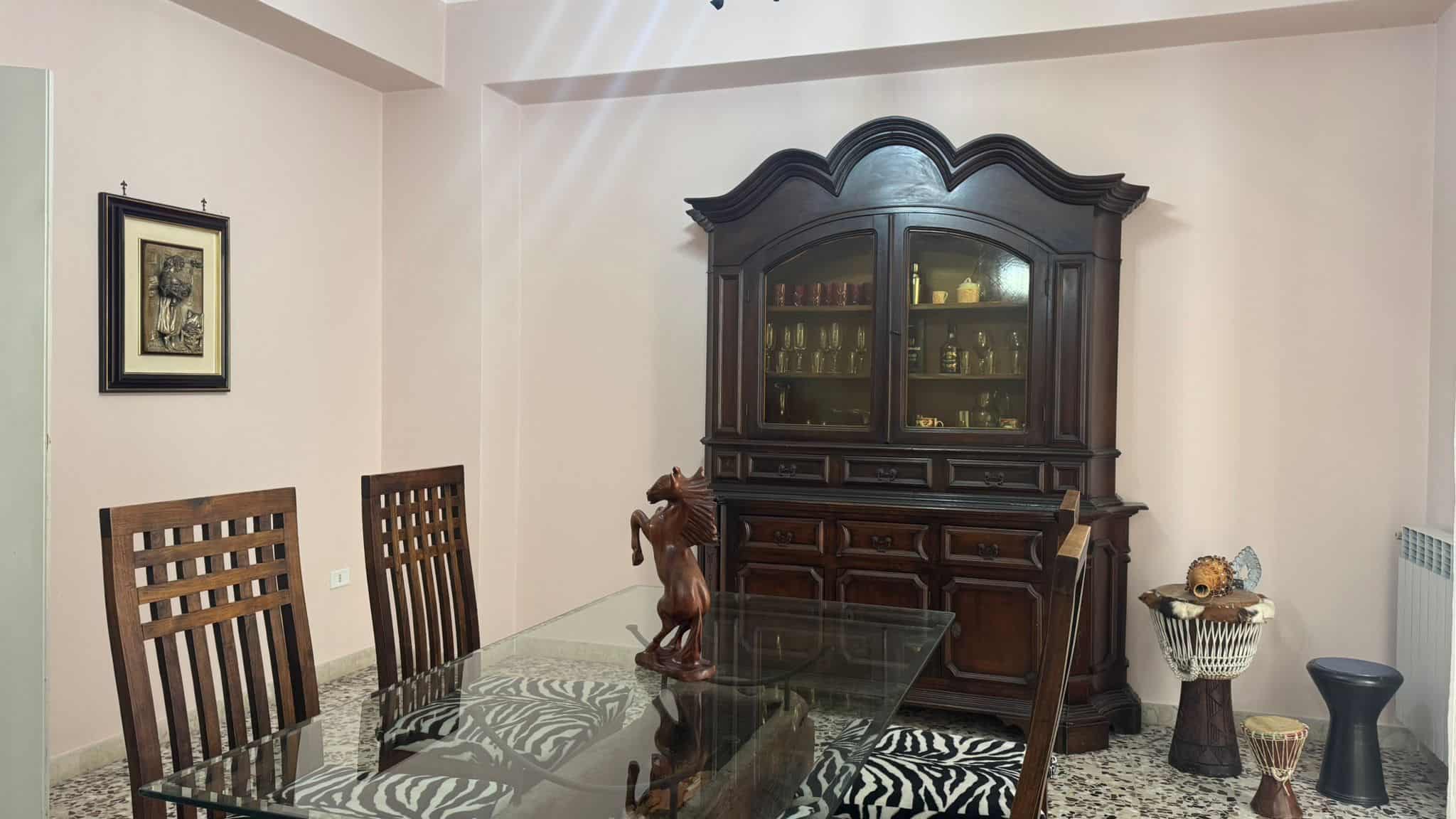Elegante mobile soggiorno in legno scuro con vetrina, ideale per arredi di case e appartamenti di alta qualità. Perfetto per valorizzare ambienti living raffinati e funzionali.