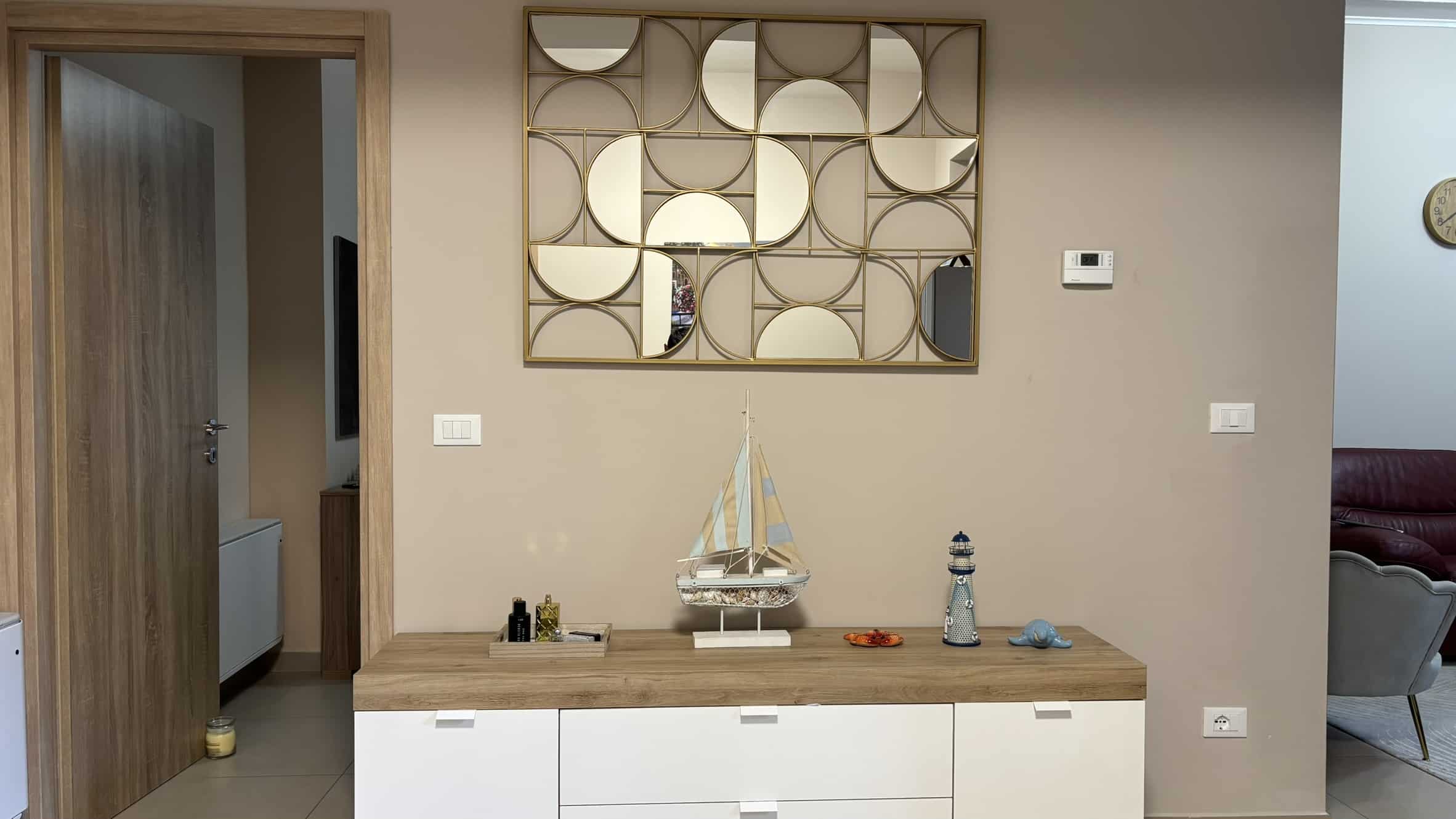 Elegante mobile ripiano in legno con decorazioni marittime e specchi decorativi, ideale per arredare l'ingresso o il soggiorno con stile nautico e modernità.