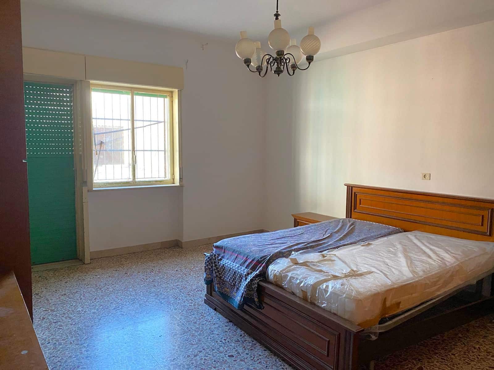 Letto matrimoniale in camera da letto in appartamento in vendita, con finestra luminosa e arredo semplice, ideale per residenze in zona tranquilla.