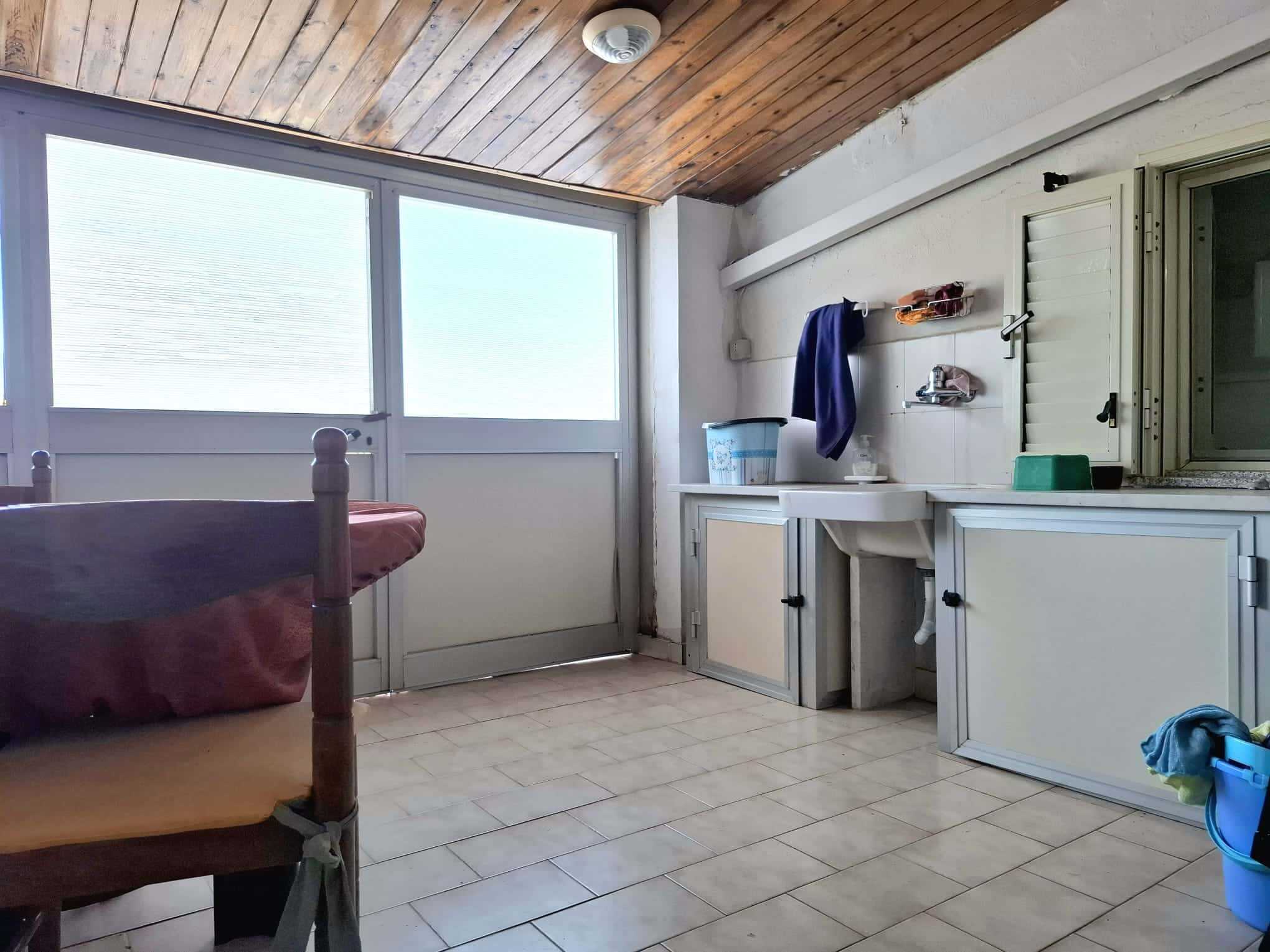 Lavanderia con finestra e accessori per il bucato, spazio funzionale per lavanderia e stiro, ambiente luminoso e pratico per le faccende quotidiane.