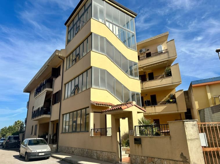 Elegante edificio residenziale con ampi balconi e un'ala con serre vetrate, perfetto per soluzioni di casa moderna e confortevole a Napoli.