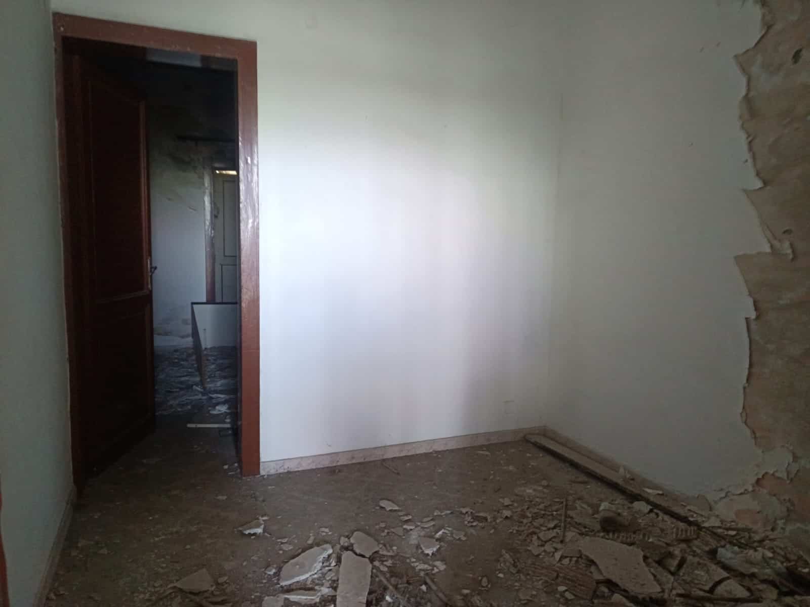 Foto di una stanza in ristrutturazione con pareti riparate, pavimento sgombro e senza arredi, immagine rappresentativa di progetti di ristrutturazione casa di NextCasa.