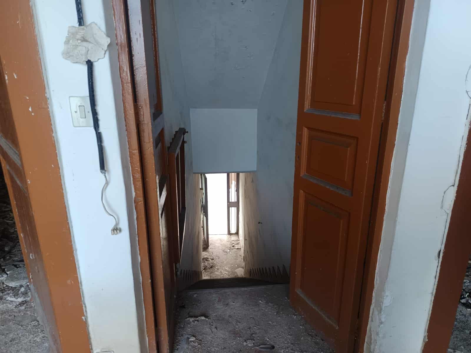 Scale di casa in costruzione con porte in legno e muratura in fase di finitura, foto di interni di un edificio da ristrutturare, dettagli di lavoro edilizio e ristrutturazione casa.