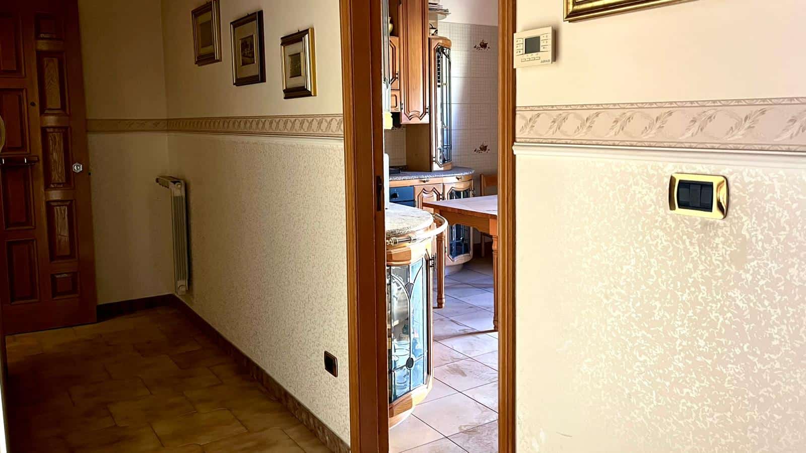 Ellisse in casa con pareti decorate, riscaldamento e accesso alla cucina rustica con mobili in legno e dettagli vintage, ideale per vivere in un ambiente accogliente e tradizionale.