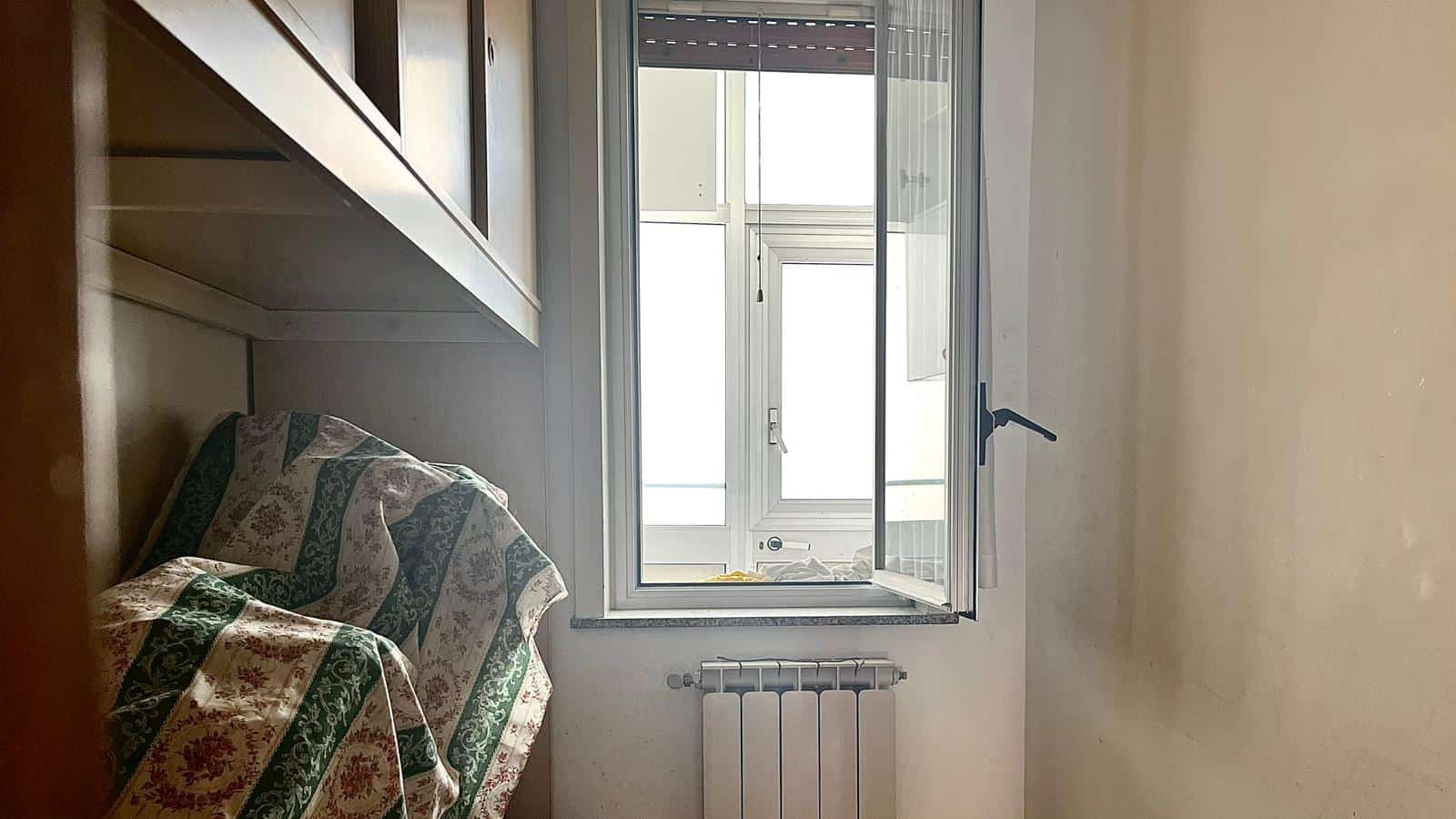 Finestra con vista su balcone in appartamento, illuminazione naturale, stile semplice e funzionale, ideale per ambienti residenziali e ristrutturazioni immobiliari.