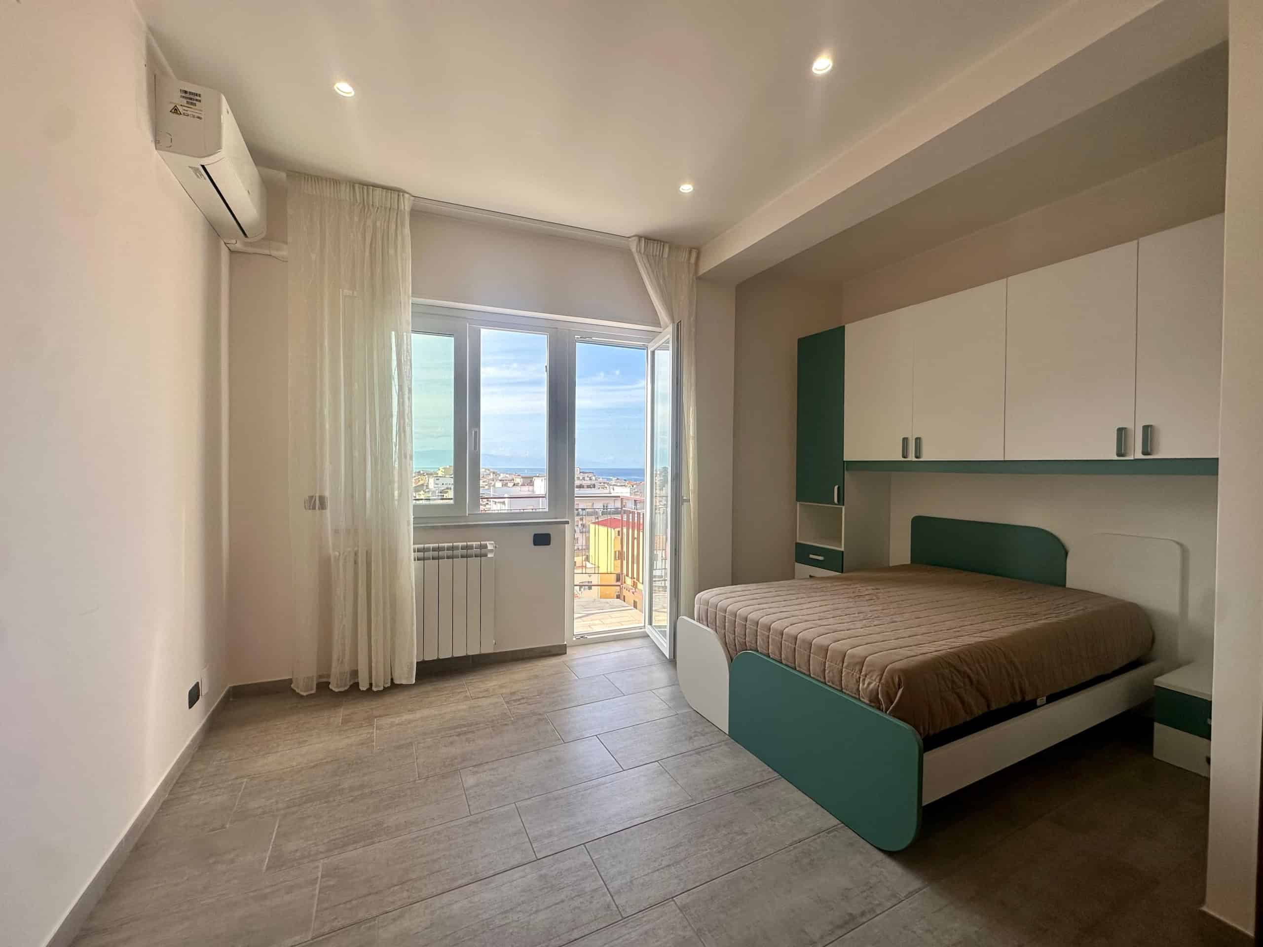 Spazio moderno con camera da letto arredata con mobili su misura, vista panoramica sul mare, ambiente luminoso e accogliente, ideale per abitazioni di alta qualità, design contemporaneo, vicino alle zone costiere italiane.