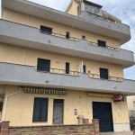 Vera facciata di appartamento residenziale in stile moderno con balconi curvi e accesso al primo piano, palazzo di altezza media in zona urbana.