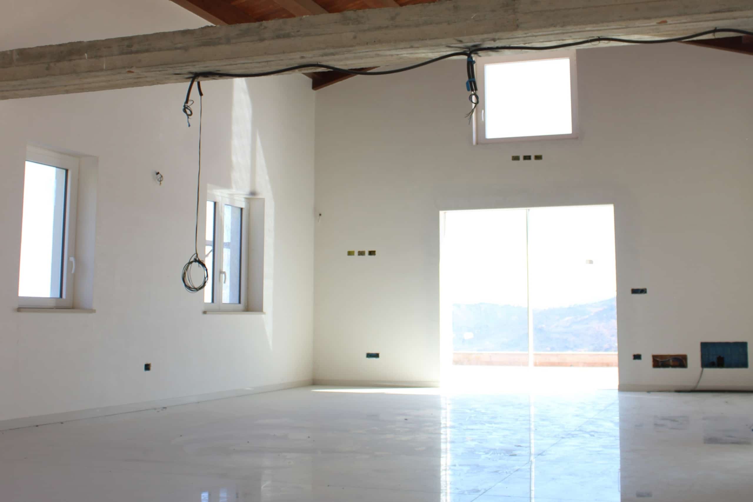 Nuova casa in costruzione con pareti bianche, grandi finestre e vista panoramica, pronto per essere arredato, processo di ristrutturazione e finitura degli ambienti abitativi moderni, progetto edilizio NextCasa.