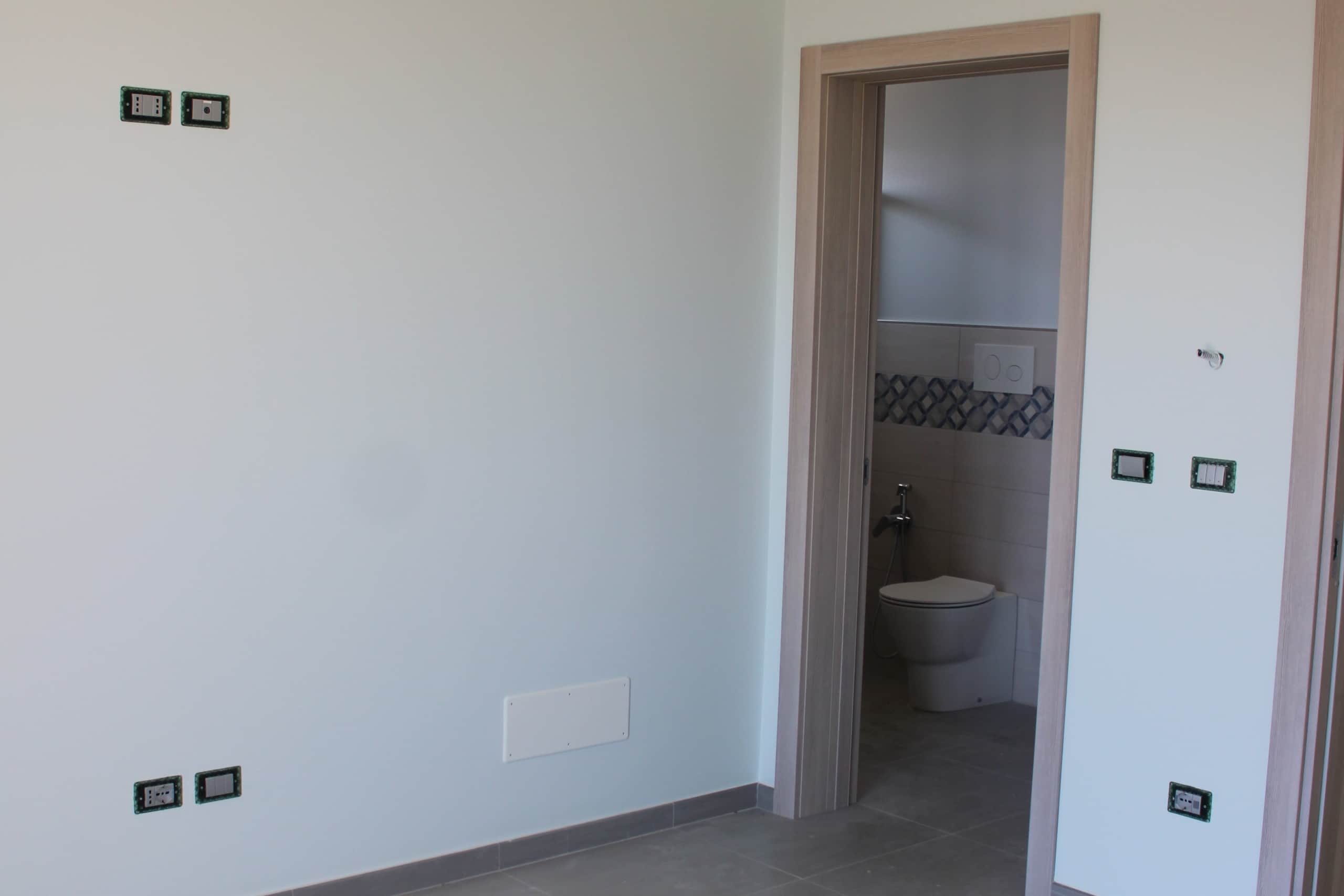 Nuova casa in costruzione con bagno e impianto elettrico in fase di completamento, finiture moderne e dettagli di design.
