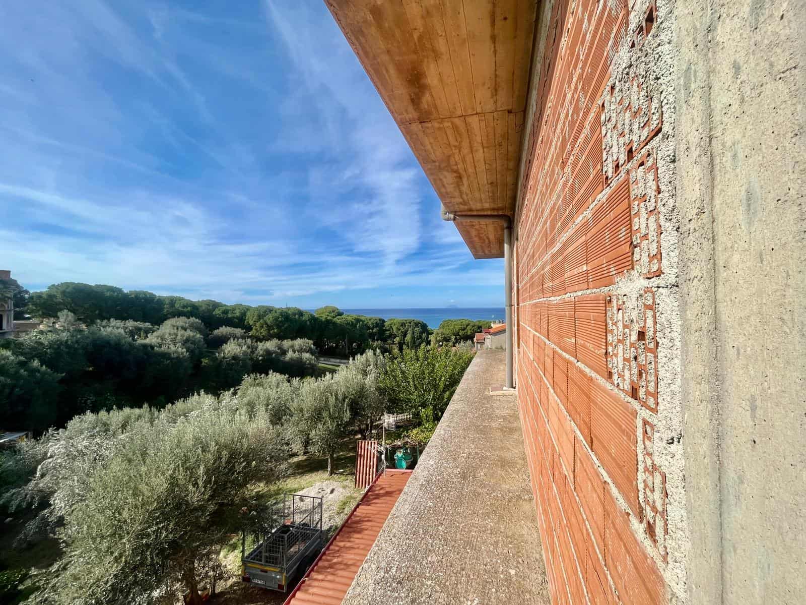 Veranda con vista sul paesaggio naturale, tra alberi e il mare, con edificio in costruzione visibile, stabile di nuova costruzione, ideale per immobili residenziali e di lusso, panorama panoramico in vista.