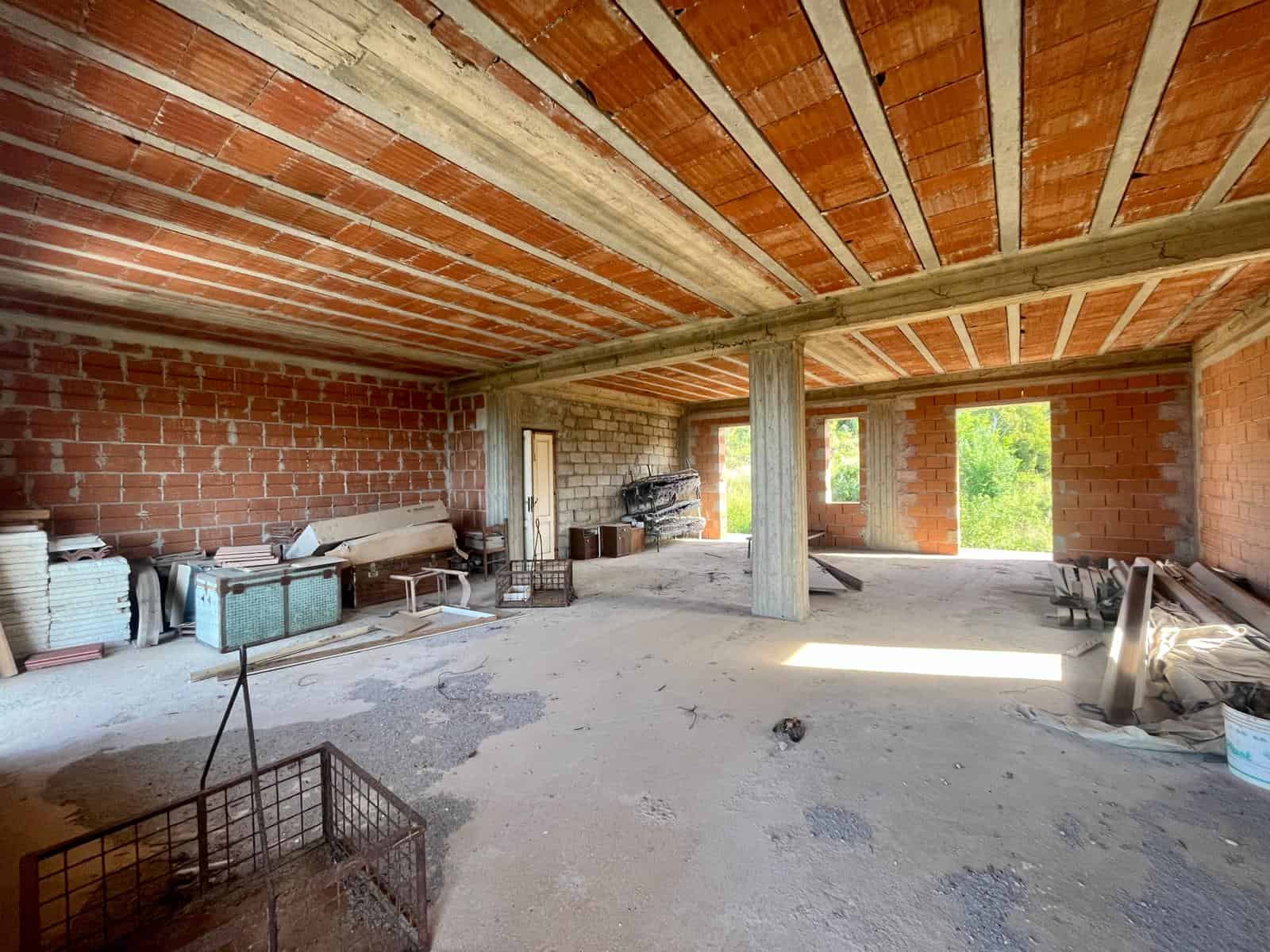Capacità di un edificio in costruzione con strutture in cemento e mattoni rossi, pronto per essere arredato e decorato, con ampie finestre e molte possibilità di personalizzazione.