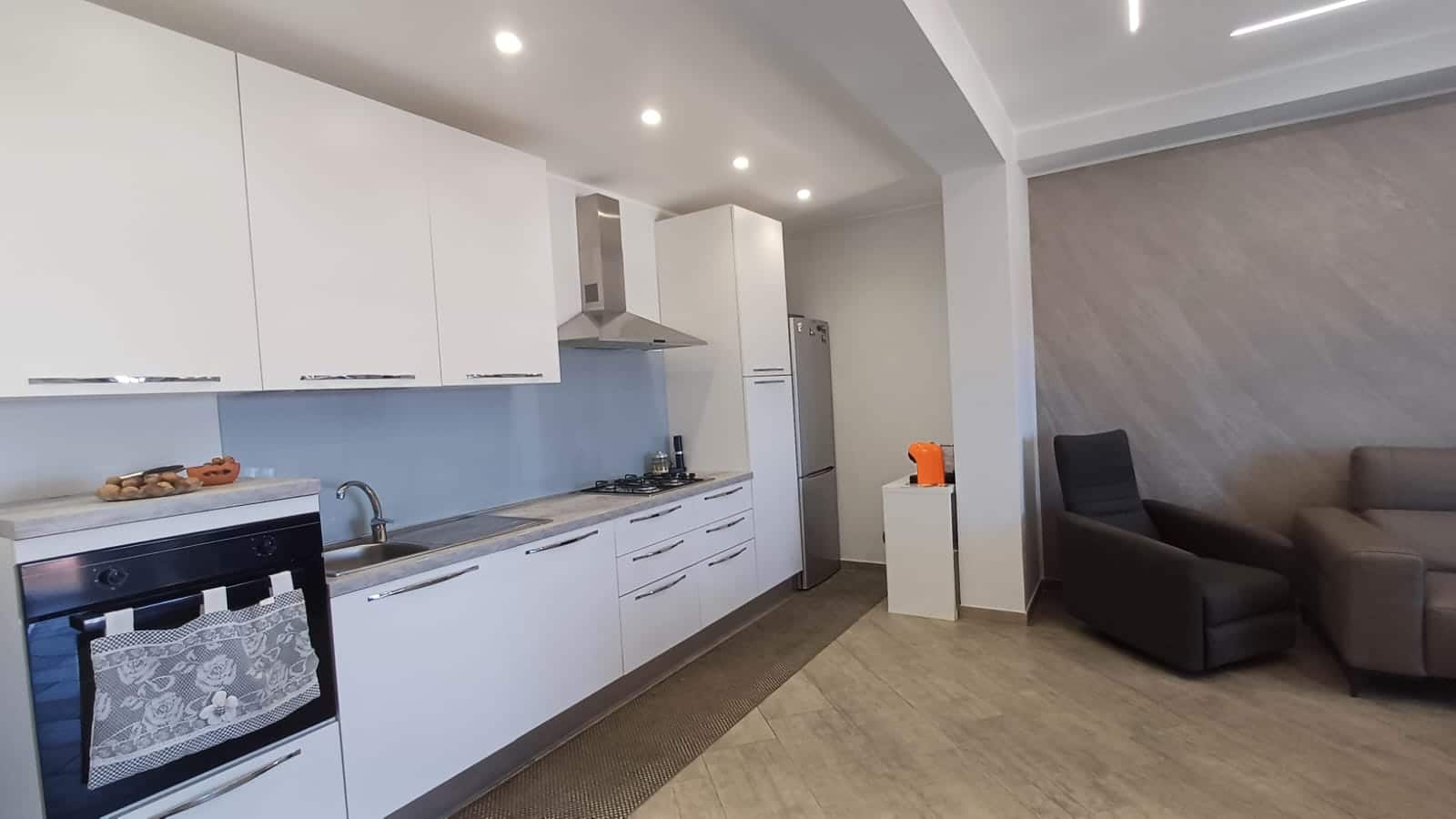 Moderno appartamento con cucina open space e zona living, arredato con stile minimalista, ideale per affitti a breve o lungo termine, vicino alle principali attrazioni di città.