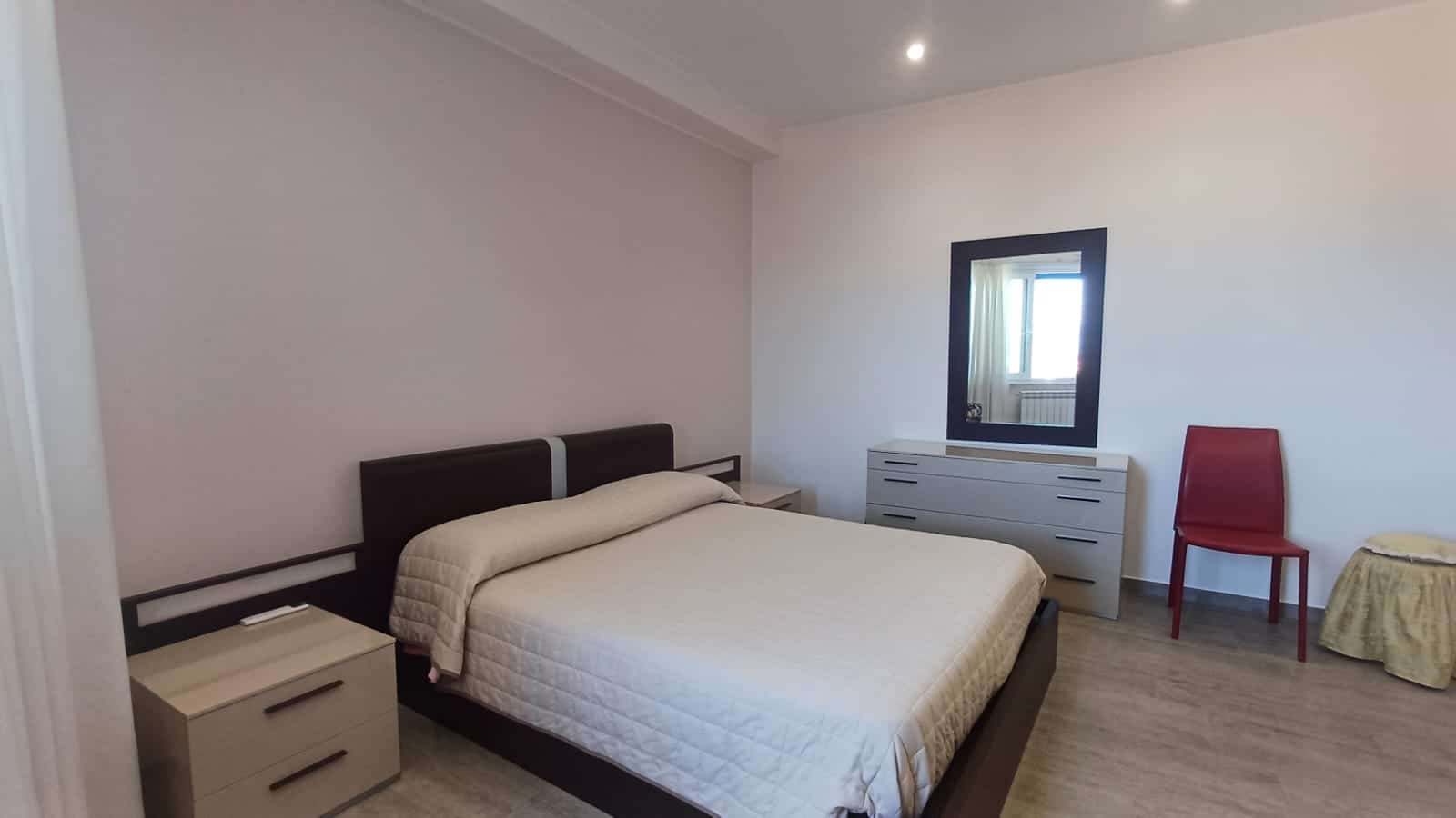 Letto matrimoniale con armadio moderno in una camera da letto elegante e luminosa, arredamento di qualità, stile minimalista, ideale per case in vendita o affitto.