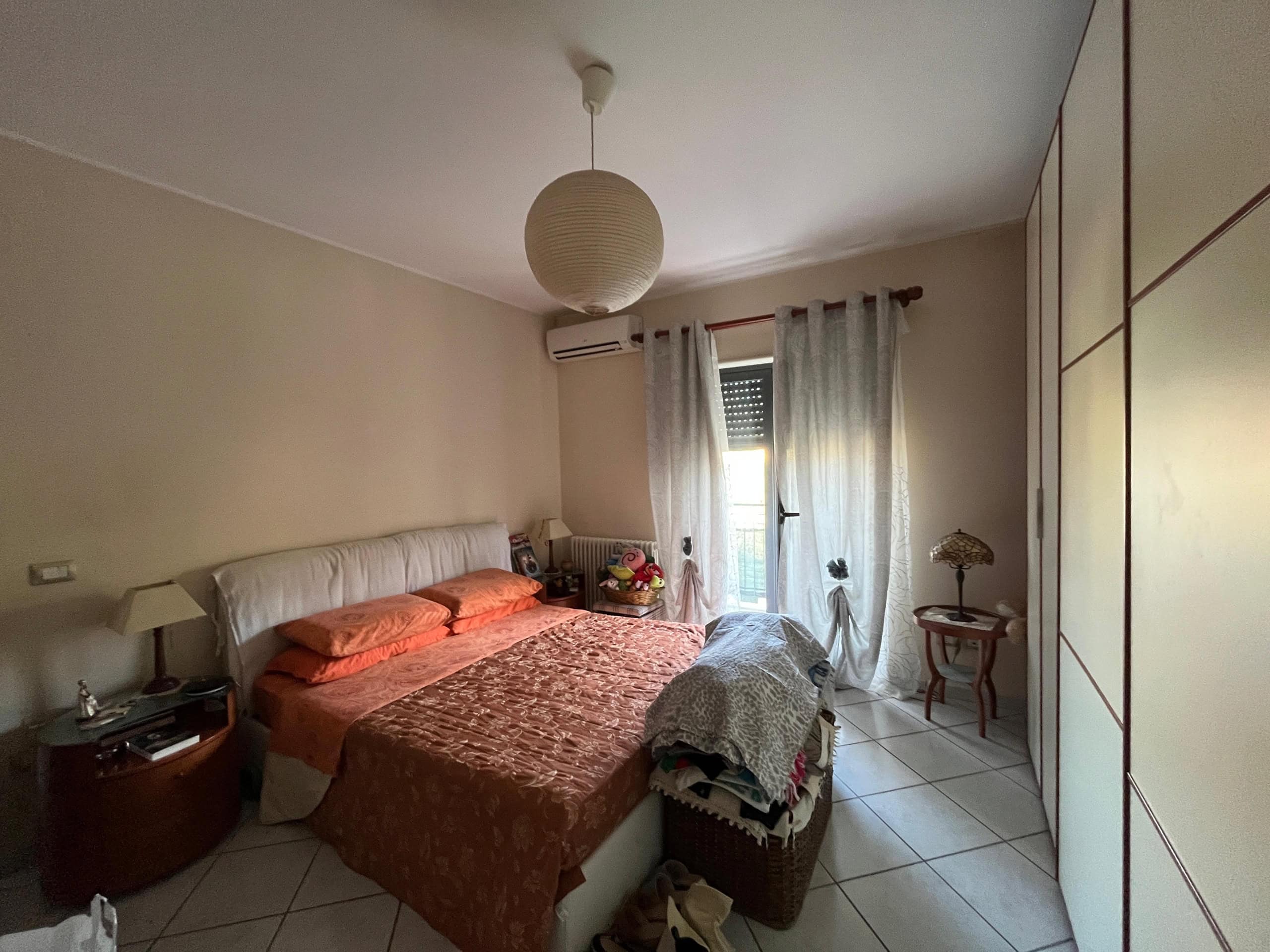 Letto matrimoniale camera da letto con armadio spazioso, arredi classici e luce naturale, ideale per appartamenti in vendita o affitto a NextCasa, agenzia immobiliare specializzata in soluzioni residenziali.
