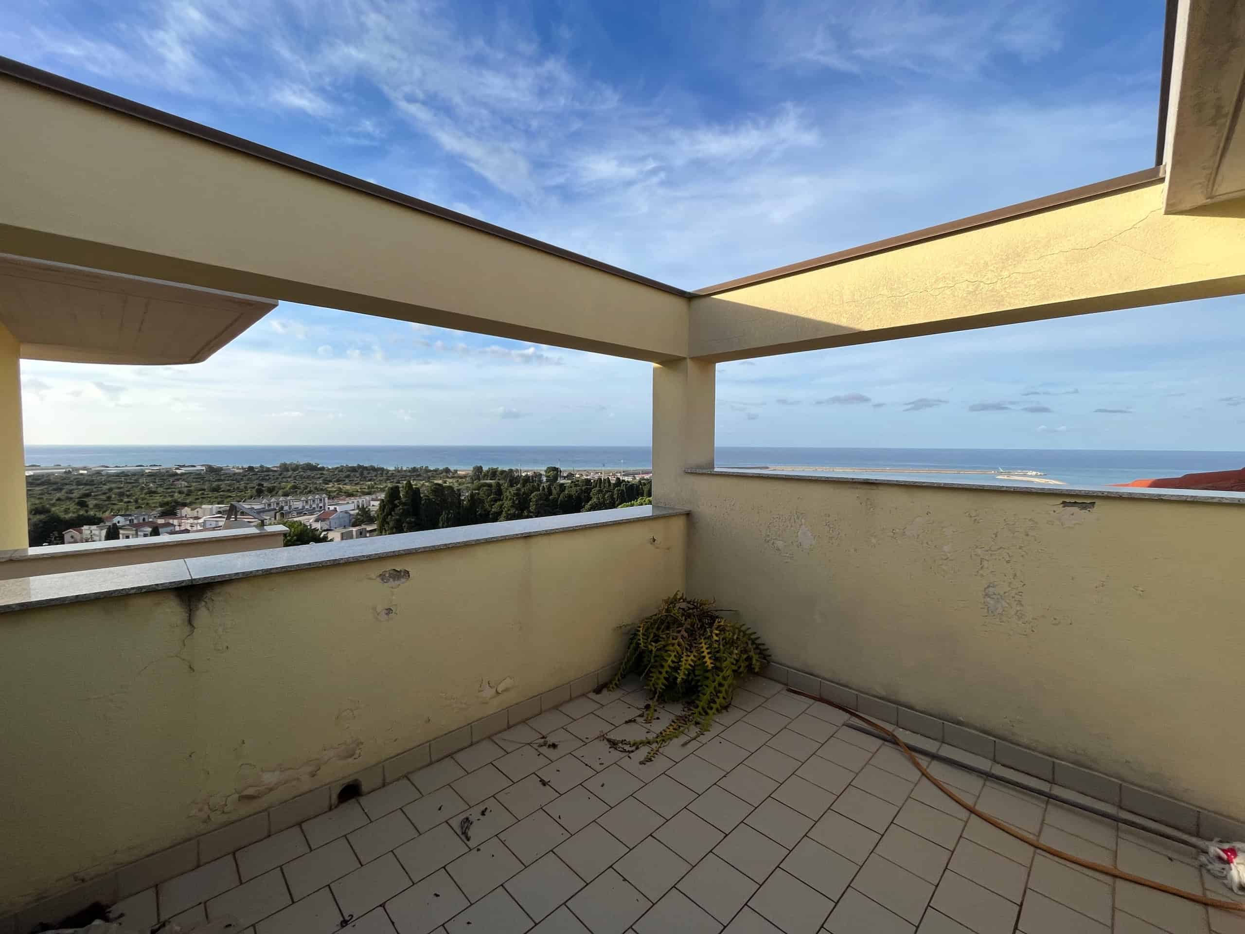 Balcone con vista mare e cielo blu, offrendo un'ampia prospettiva sulla costa e sulla natura circostante, ideale per relax e godersi il panorama.