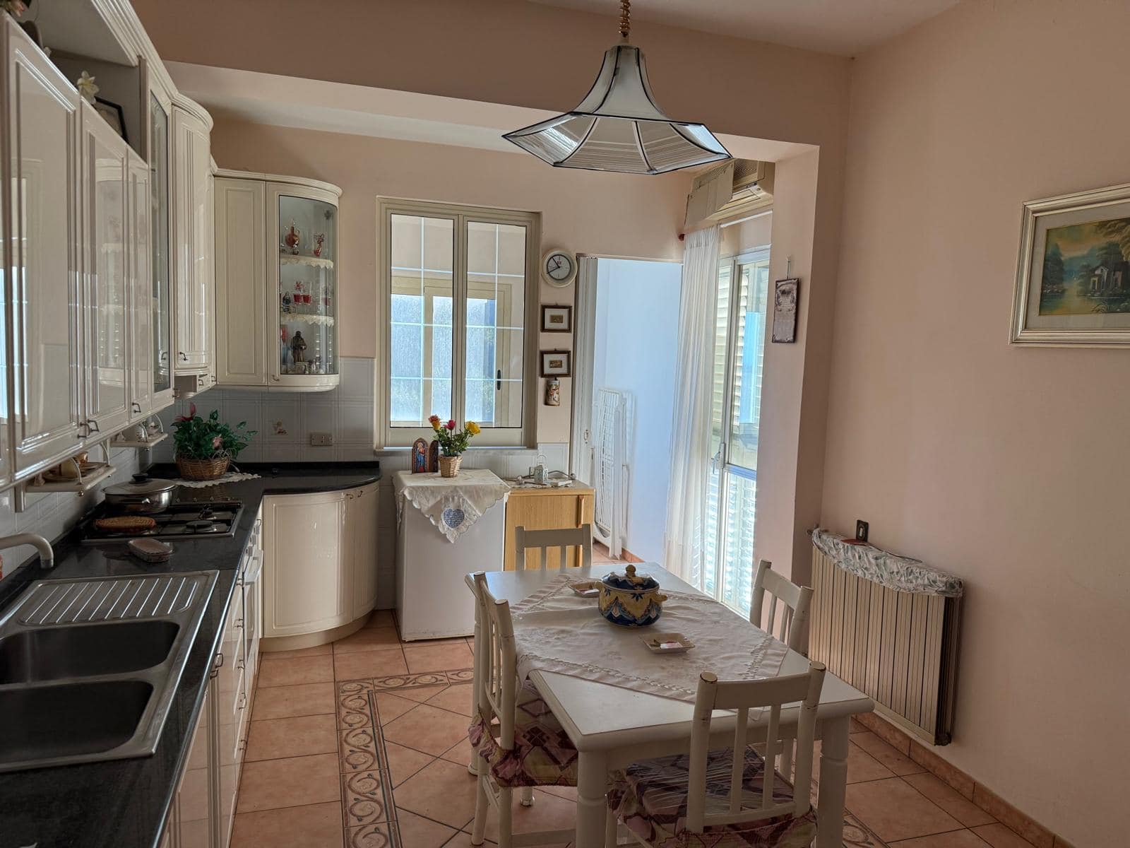 Pomodoro cucina moderna in stile classico con tavolo da pranzo, pareti in tonalità neutre, finestre luminose, arredamento elegante, dettagli decorativi e accessori in cucina, ideale per ambienti residenziali.