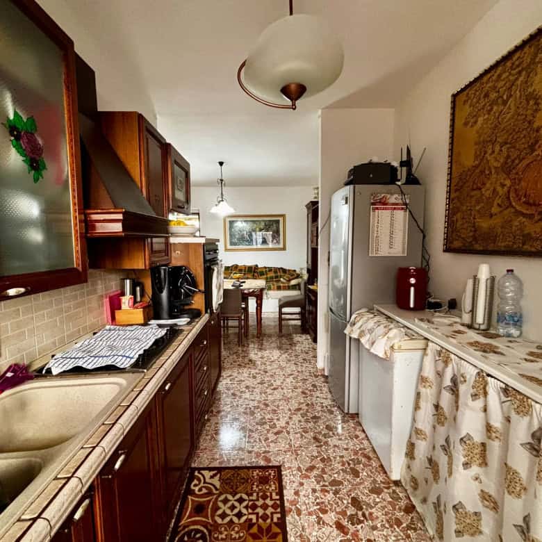 Lavastoviglie e cucina in stile tradizionale in una casa di NextCasa, con mobili in legno, dettagli decorativi e un ambiente caldo e accogliente. Perfetto per chi cerca soluzioni abitabili pratiche e funzionali.