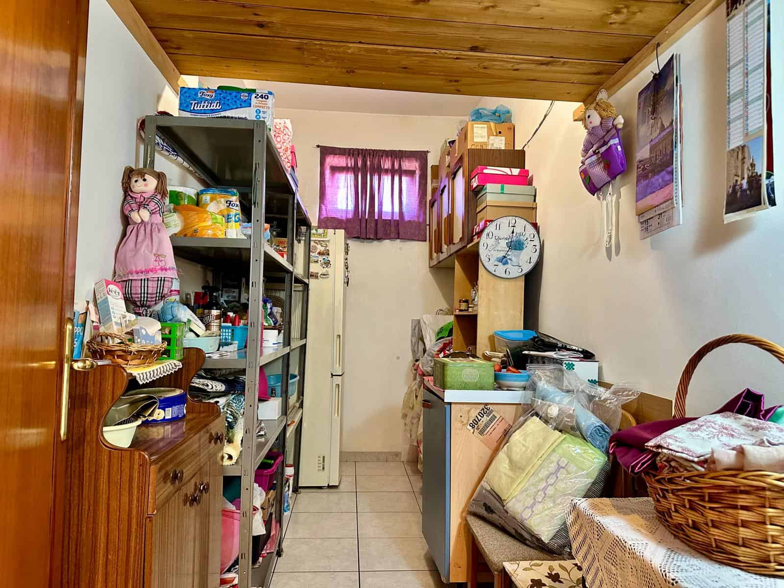 Ripostiglio confusionale con scaffali pieni di prodotti domestici e oggetti vari, spazio funzionale e sfruttato in modo pratico, ideale per riparare o conservare utensili e materiali domestici.