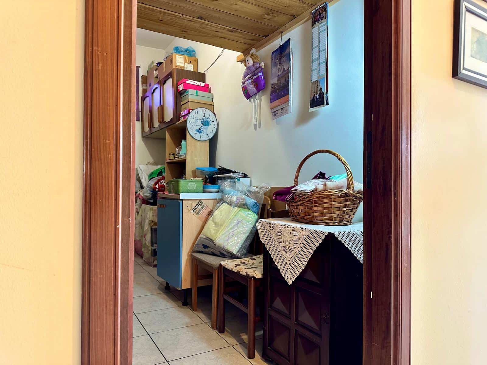 Scaffale con scatole e oggetti vari, zona di stoccaggio domestico, interno di casa, arredo funzionale, disordine organizzativo, ambiente abitativo.