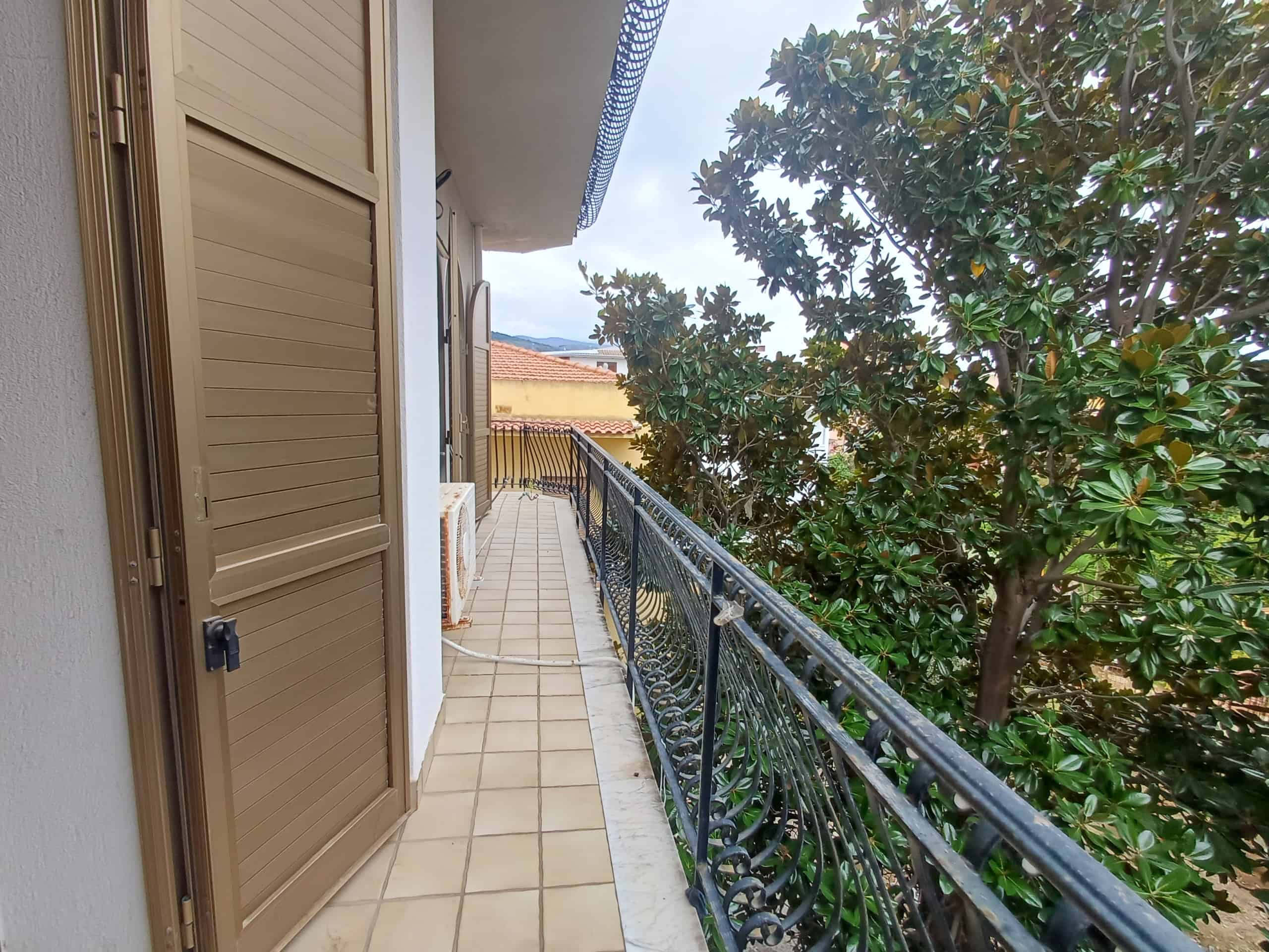Ampia terrazza panoramica con vista sulle verdi piante Adelfa, ideale per relax all'aperto e momenti di convivialità in stile casa moderna.