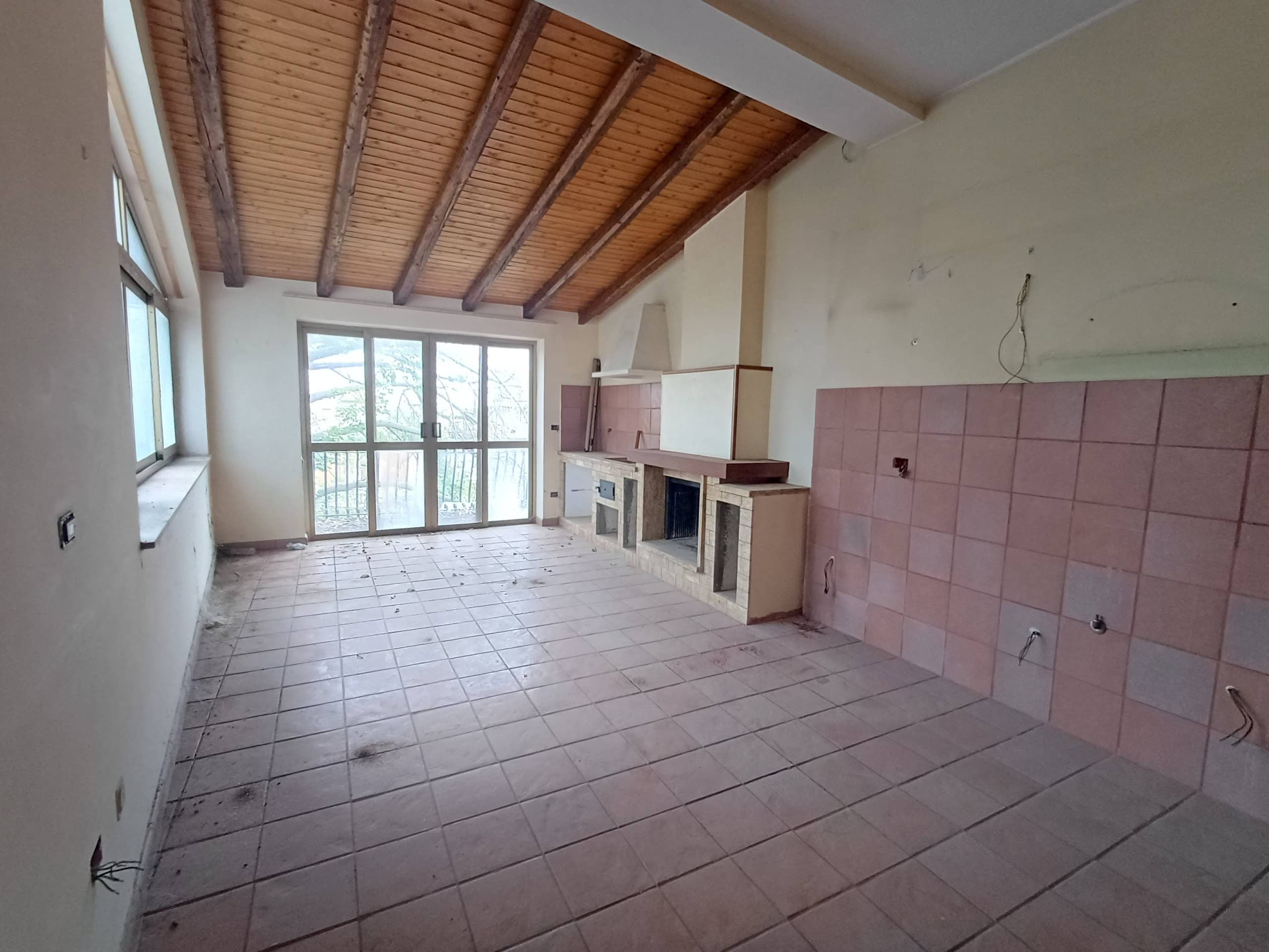 Ampio soggiorno con camino e vista panoramica, possibile personalizzazione. Ideale per investimenti immobiliari, con grandi spazi e luce naturale, pronto per essere arredato.